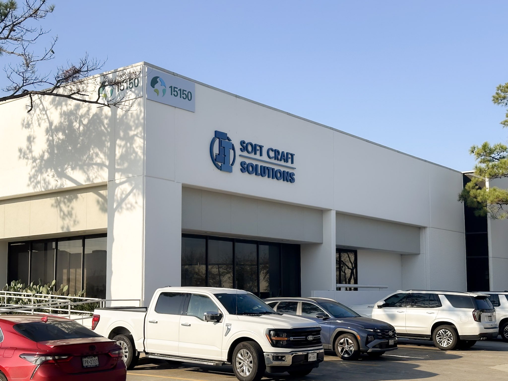 Soft Craft Solutions exterior building sign mounted above the entrance of a commercial office building in Houston.