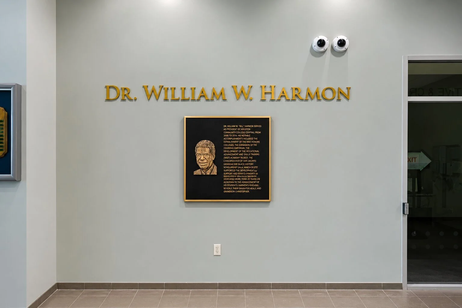Bronze recognition plaque with relief portrait and dimensional lettering honoring Dr. William W. Harmon installed on an interior HCC wall.