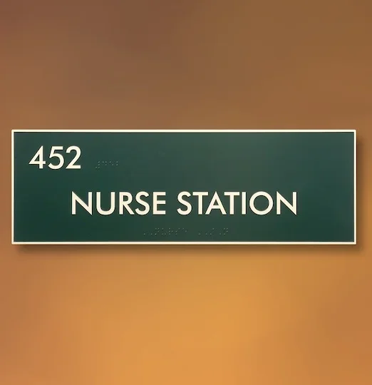 Framed ADA nurse station sign with tactile text and Braille for room 452, Houston healthcare facility.