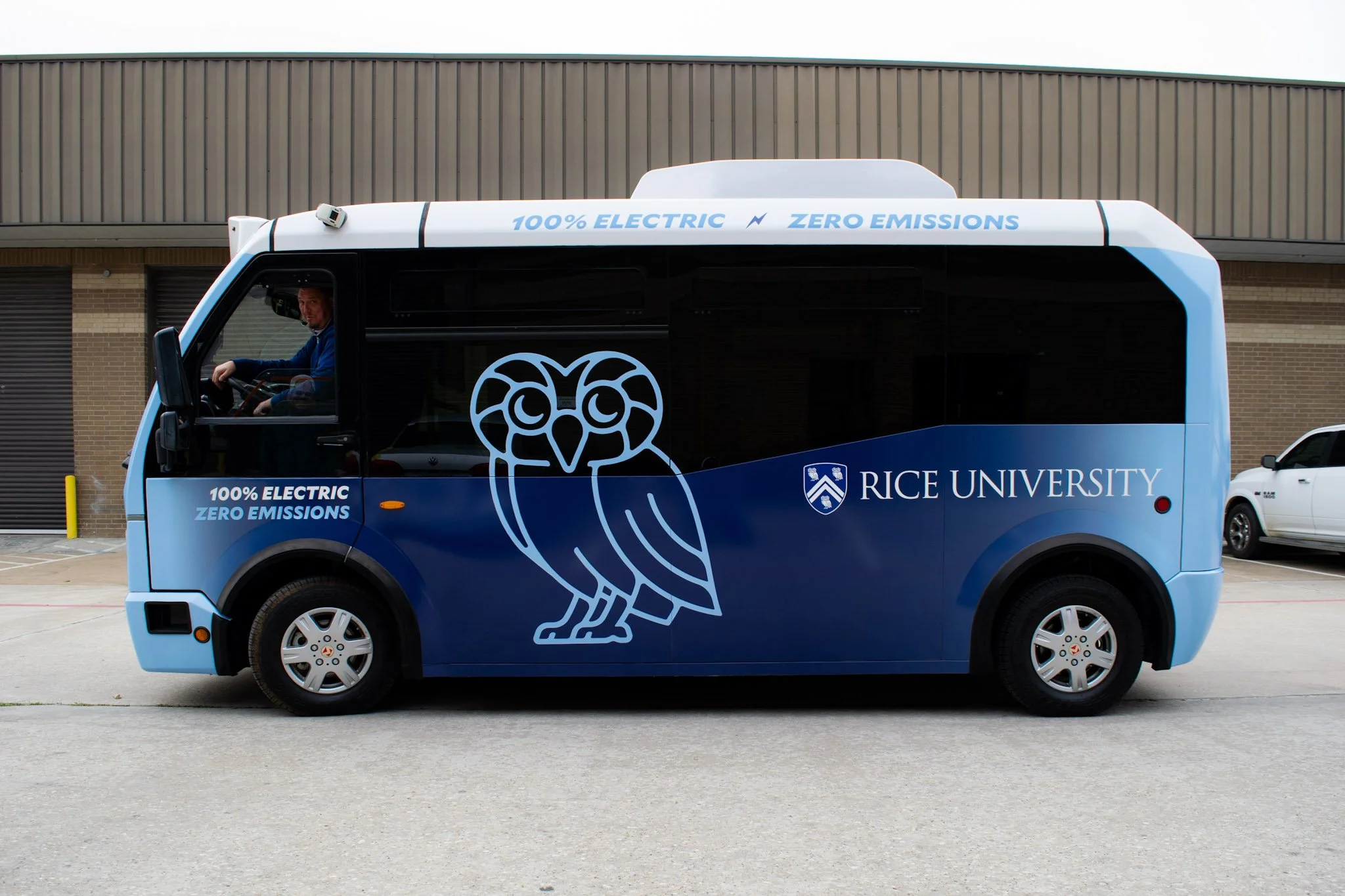Custom fleet wrap on a Rice University electric shuttle bus featuring university branding, owl graphics, and zero-emissions messaging, installed by Saifee Signs in Houston.