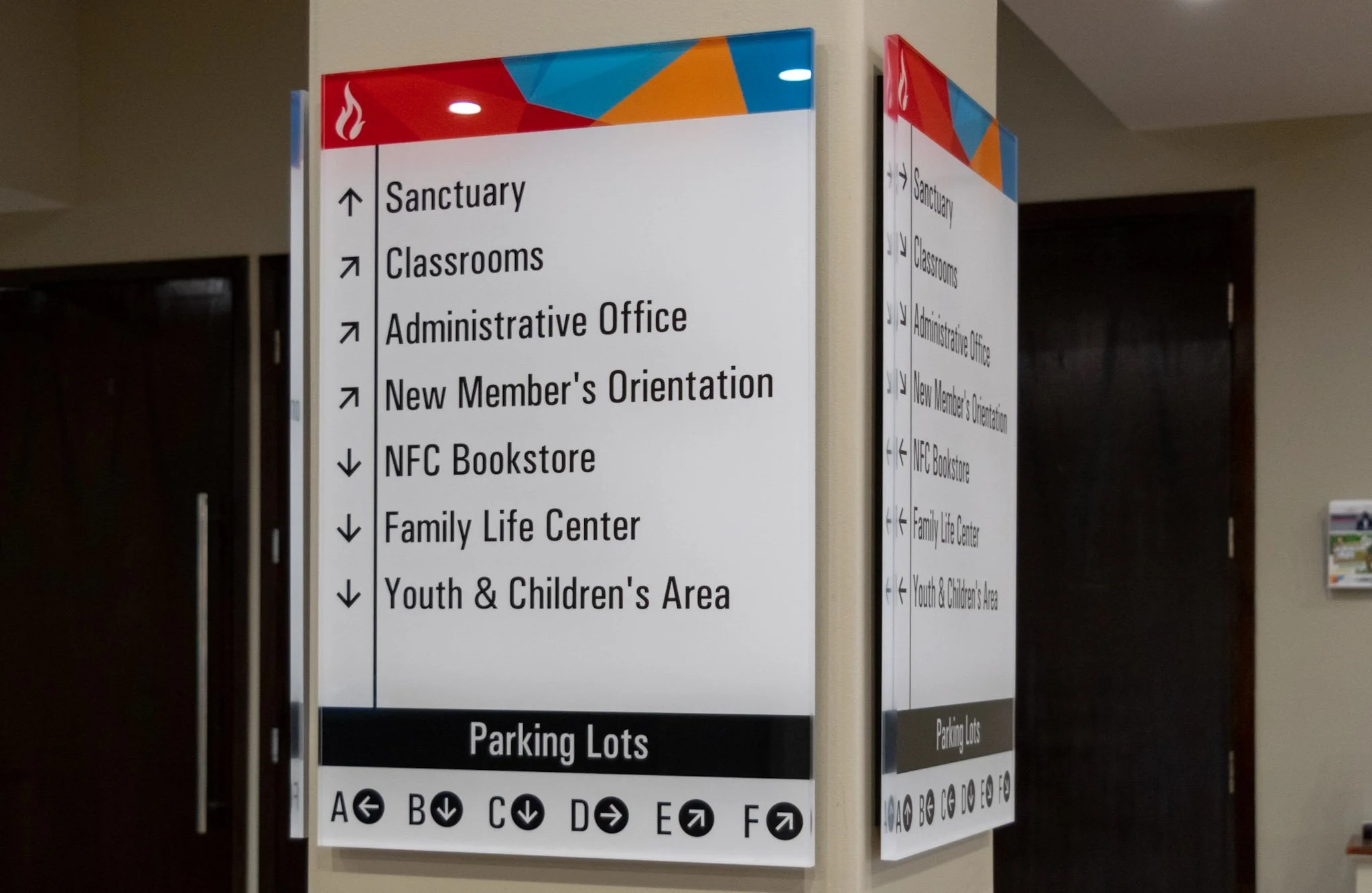 Double-sided church directory sign with directional arrows for the sanctuary, classrooms, offices, and parking lots.