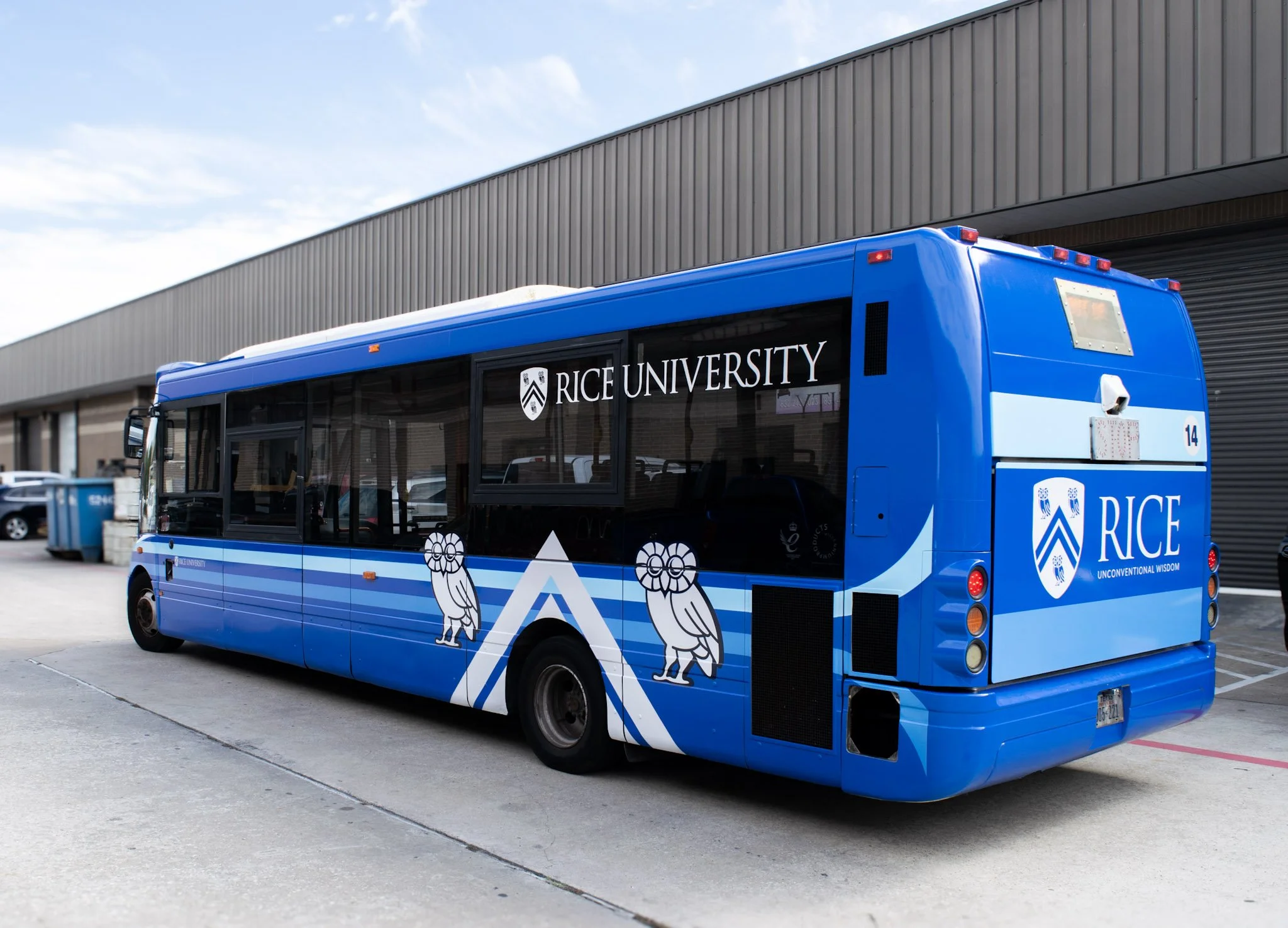 Rear side view of a custom Rice University shuttle bus wrap installed by Saifee Signs, featuring university branding, owl graphics, and campus fleet graphics.