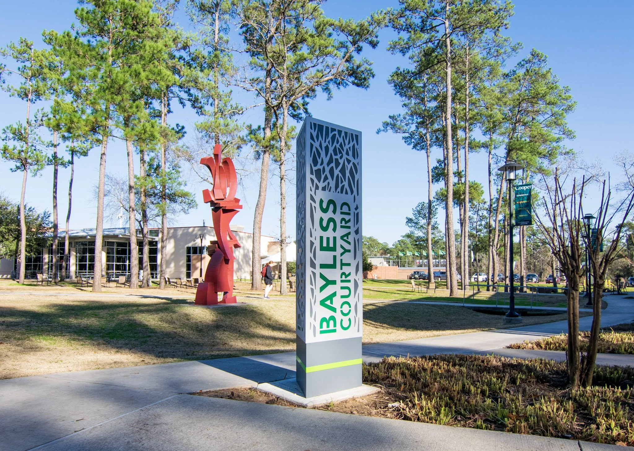 Custom Bayless Courtyard monument sign with decorative cutout panel installed at The John Cooper School in The Woodlands, Texas.