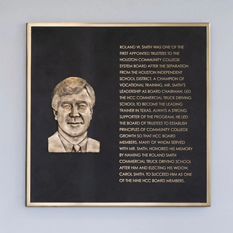 Cast bronze dedication plaque for Houston Community College featuring a raised portrait of Roland W. Smith with commemorative text.