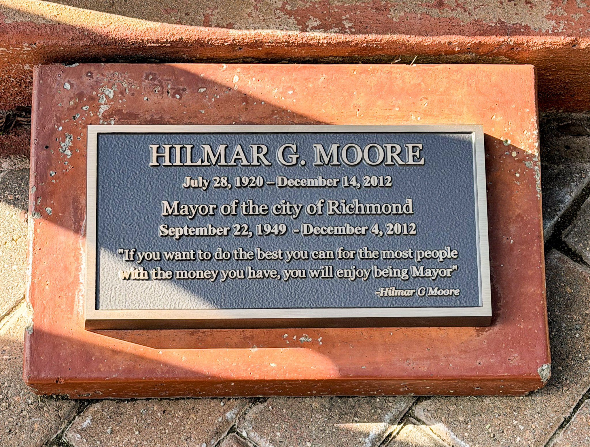 Bronze memorial plaque honoring longtime Richmond Mayor Hilmar G. Moore, mounted outdoors on a masonry base.
