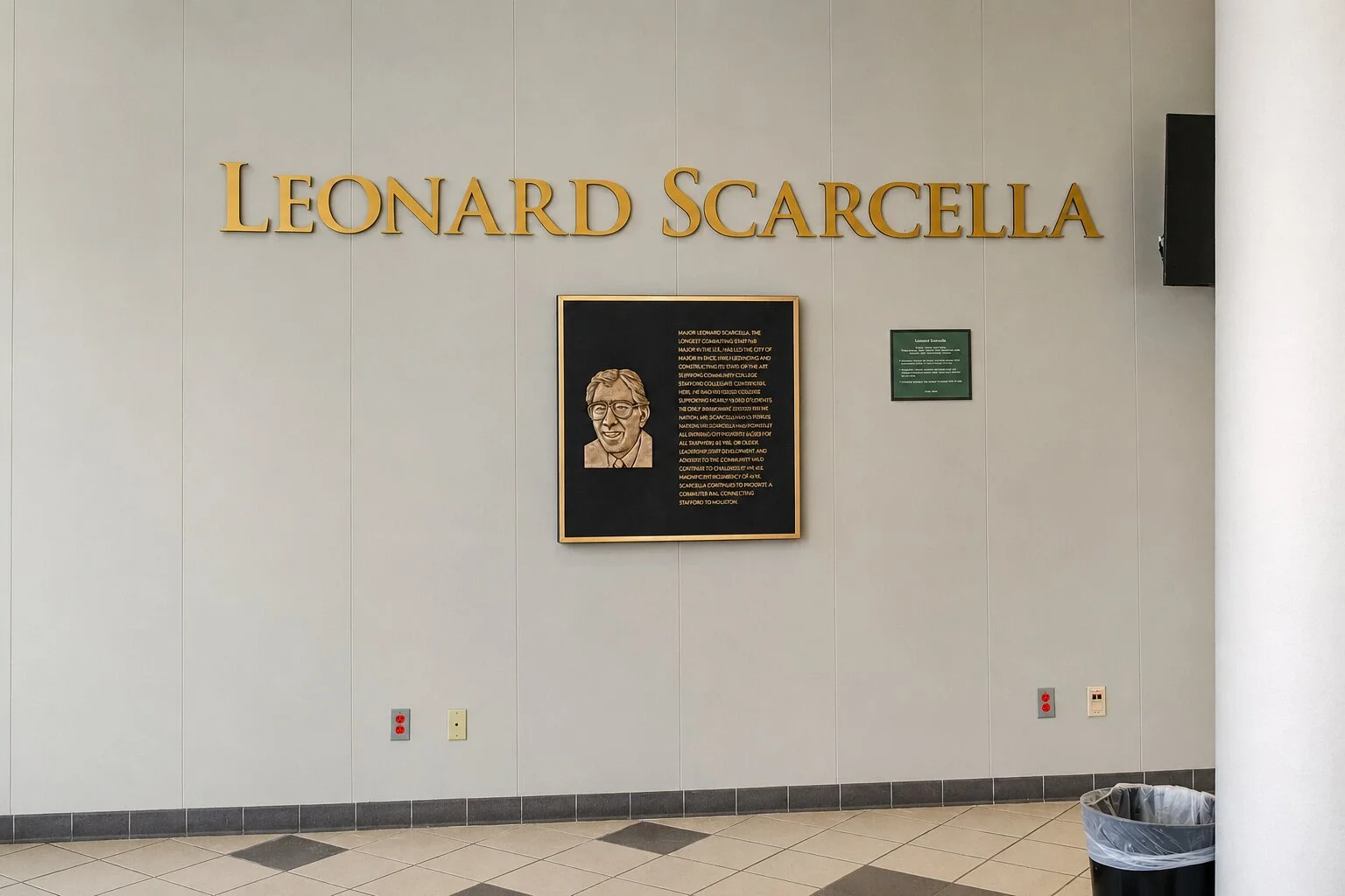 Bronze recognition plaque with portrait and dimensional lettering honoring Leonard Scarcella at a Houston Community College campus.