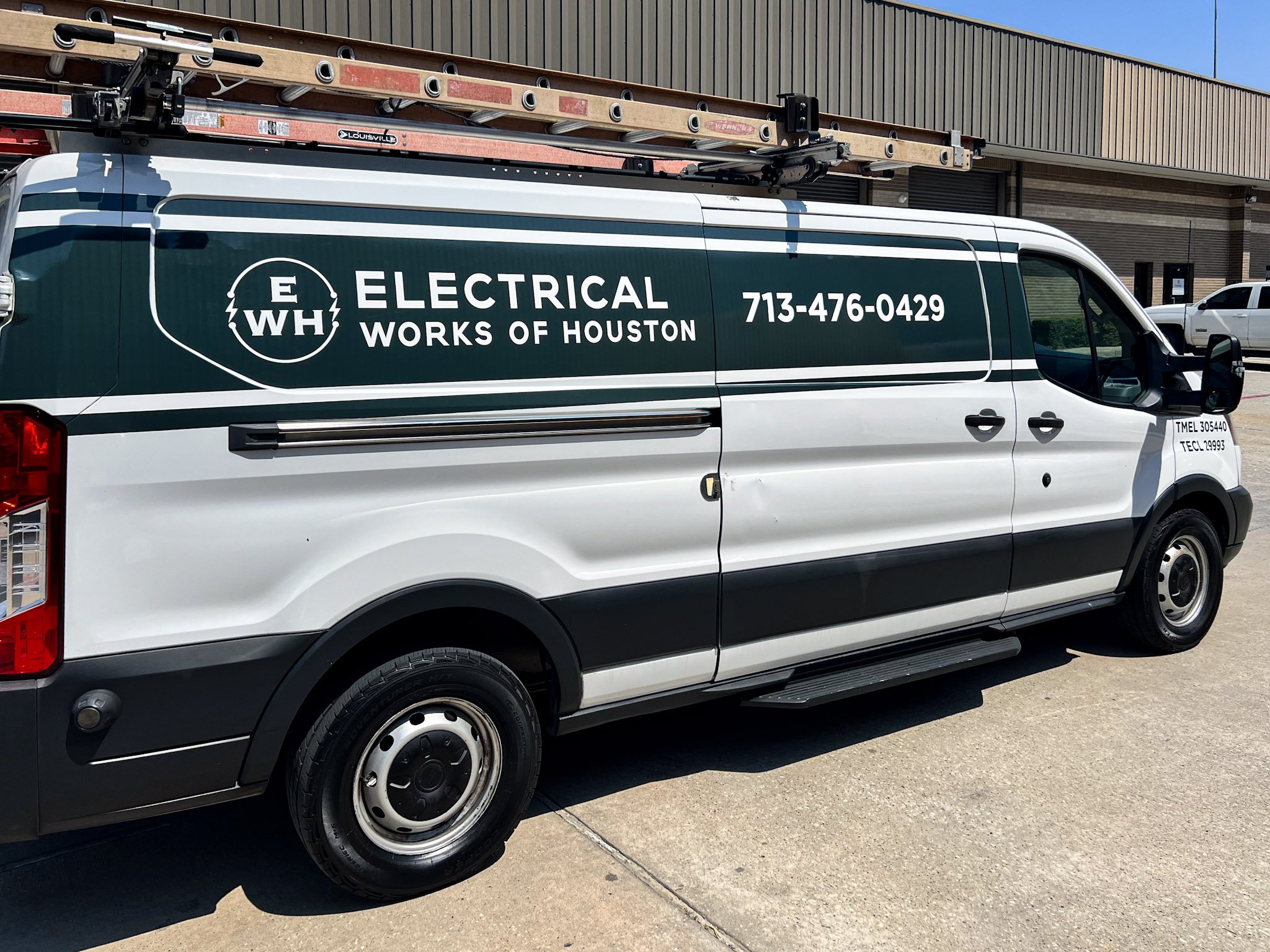 Electrical Works of Houston service van wrap with green and white branding and ladder rack, parked outside industrial building in Houston.
