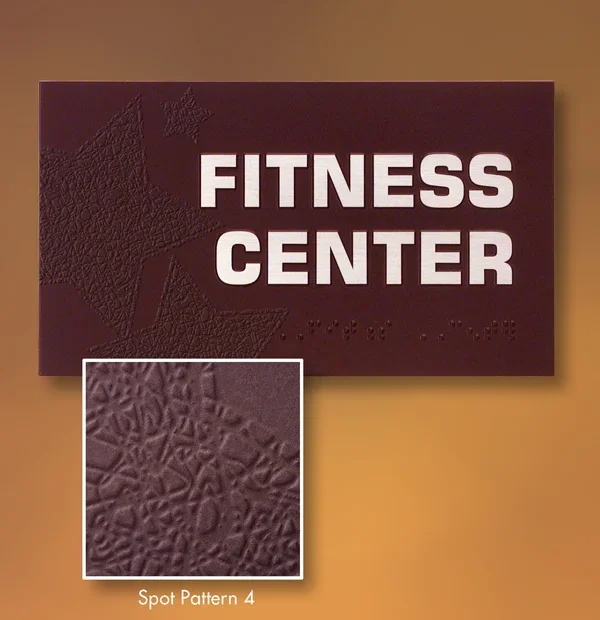 Textured 3D ADA fitness center sign with embossed organic pattern and raised tactile lettering, decorative ADA signage in Houston.