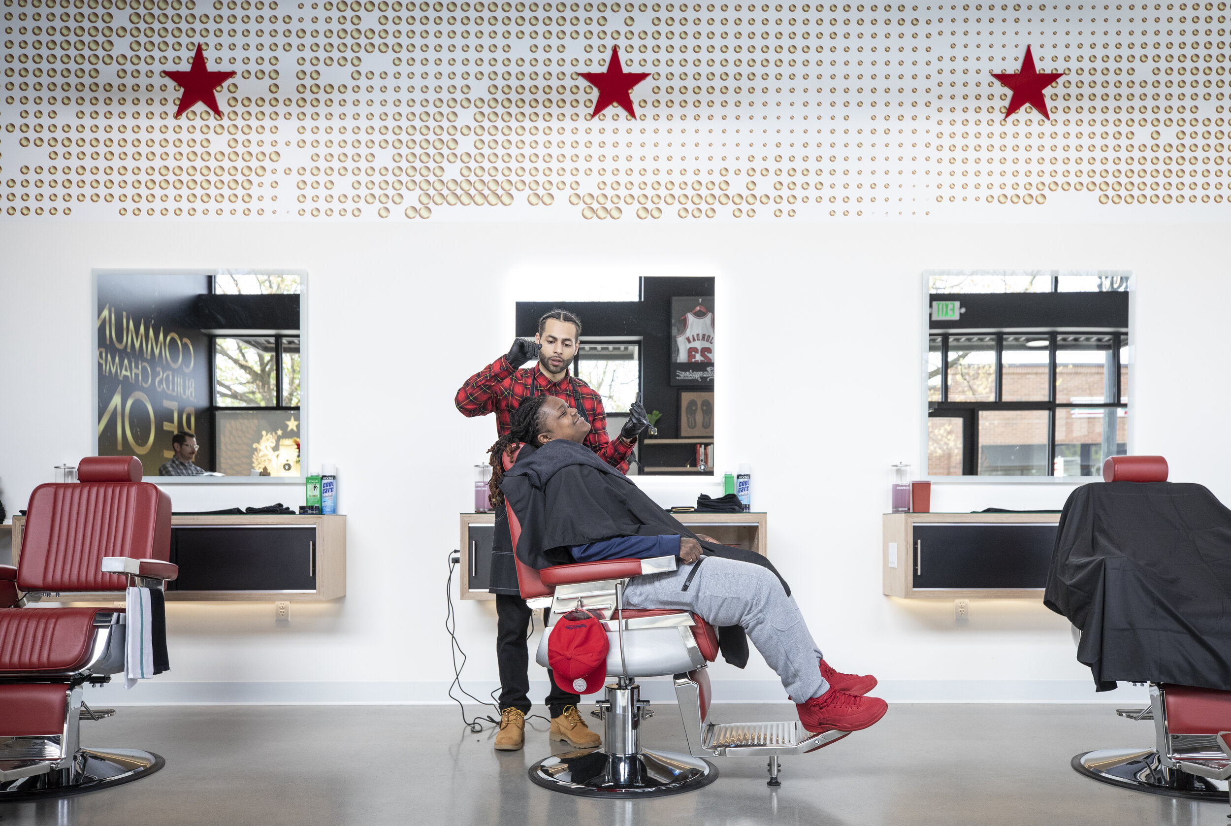 Will Smith cuts the hair of Dominique King in Champions Barbershop at the new Alberta Commons.