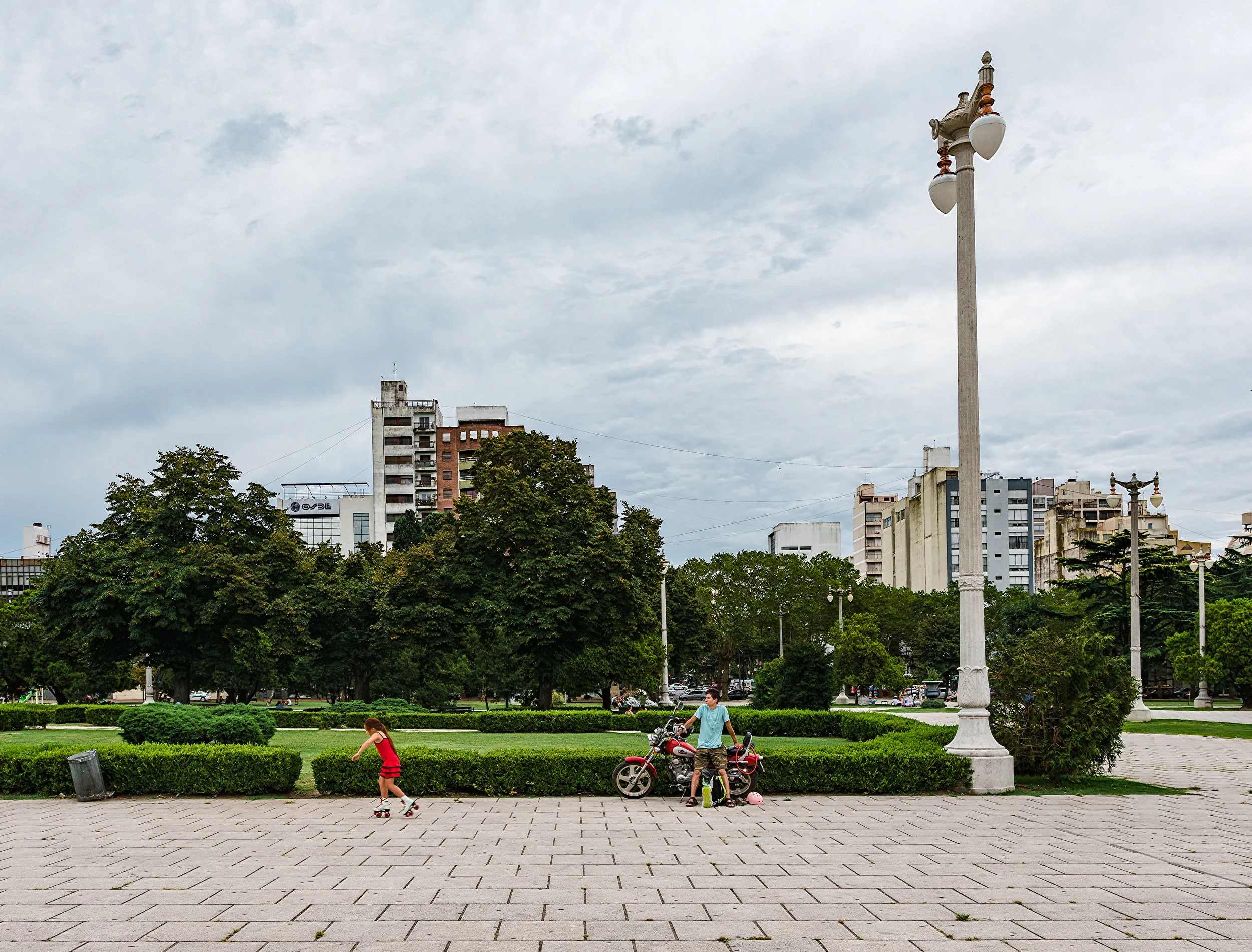 Una niña y su papá pasan tiempo juntos en una plaza en la plata. Papá los llevó allí en moto.