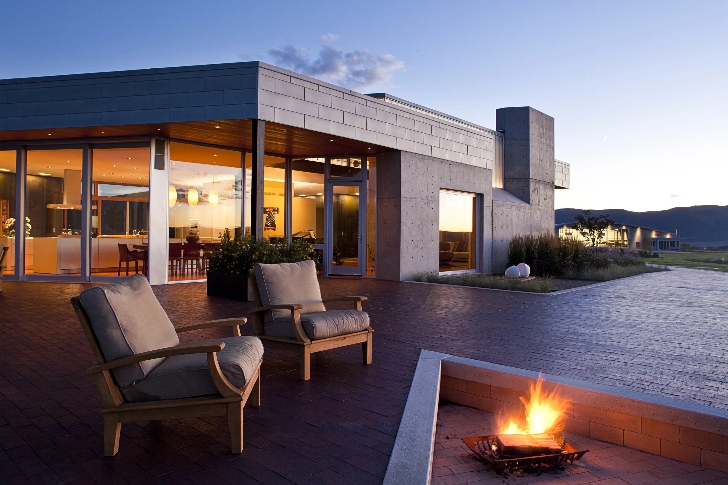 Evening fire on the north patio of a modern house near Durango, CO by Clark & Chapin Architects