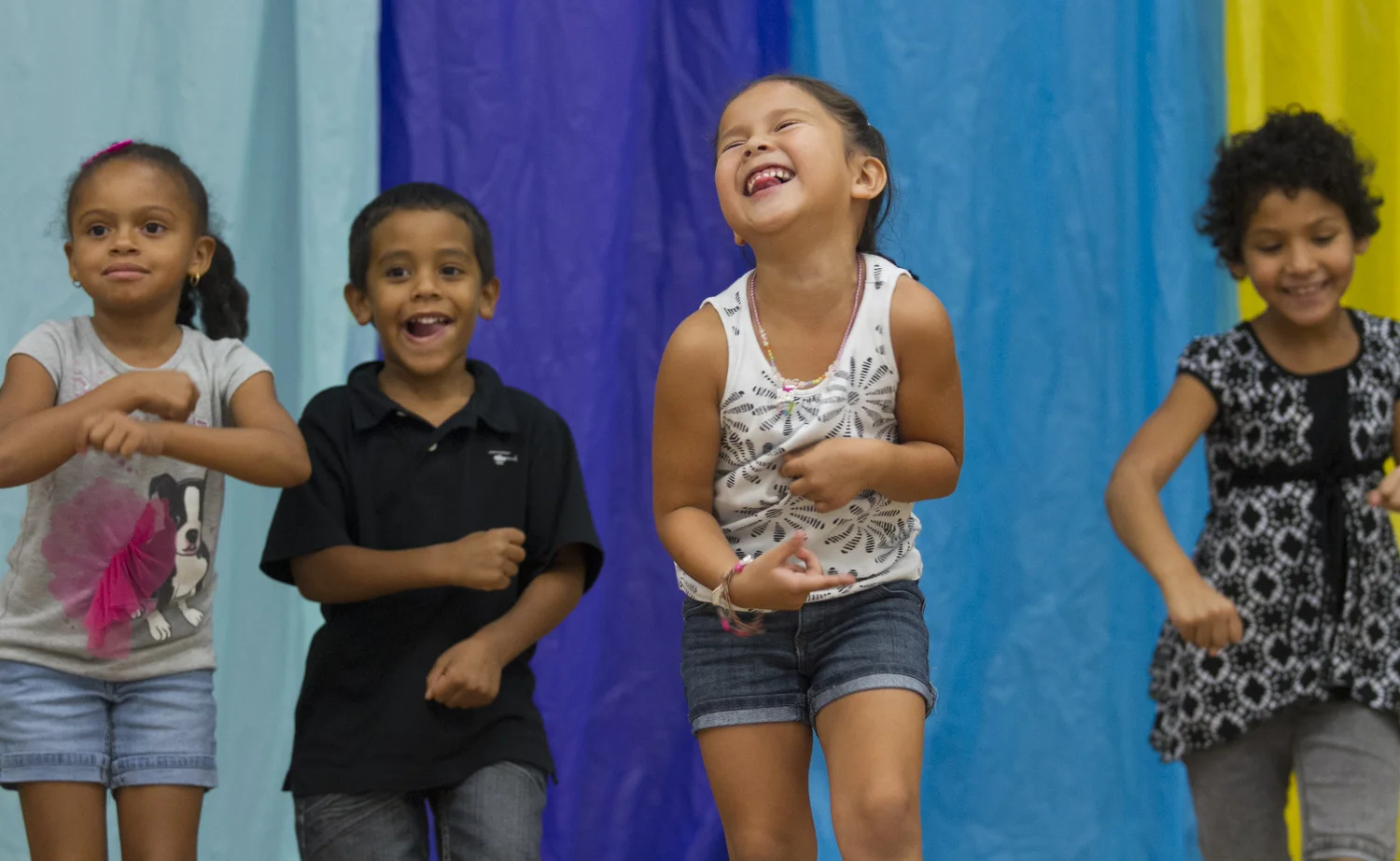 Jaliyah Duke, left, Darius Johnson, Aleis Alvarado, center, and Bethsada Valentin perform the Cha Cha Slide in a talent show at The Heights Center celebrating the end of their Brilliant Summer Camp. About 110 children ages 5-15 performed in the show