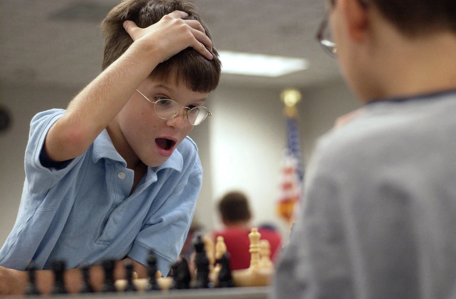 Jason Moore, left, 8, of Fort Myers reacts to losing at a game of chess against his 11-year-old opponent Jake Malatak.