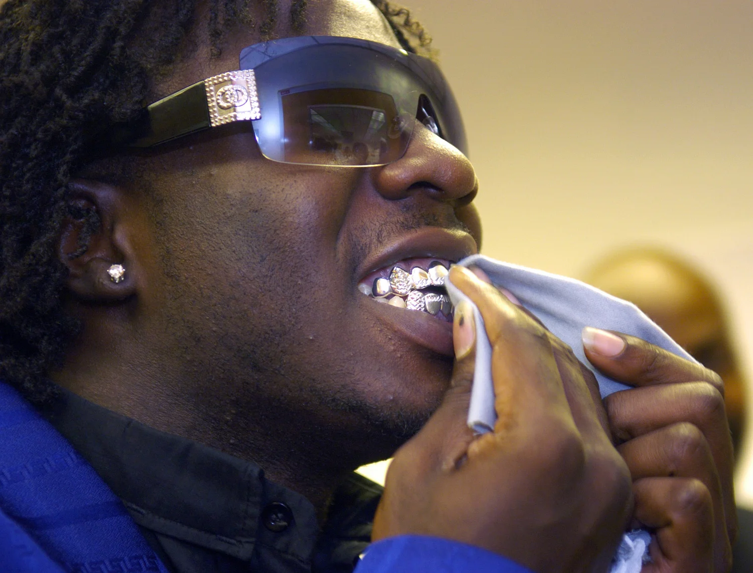 Immokalee High School senior Eliezer Alce polishes his teeth after signing his letter of intent to play college football. Alce and his teammates Nesly Saintervil and Esdras Deperard plan to attend North Iowa Community College.