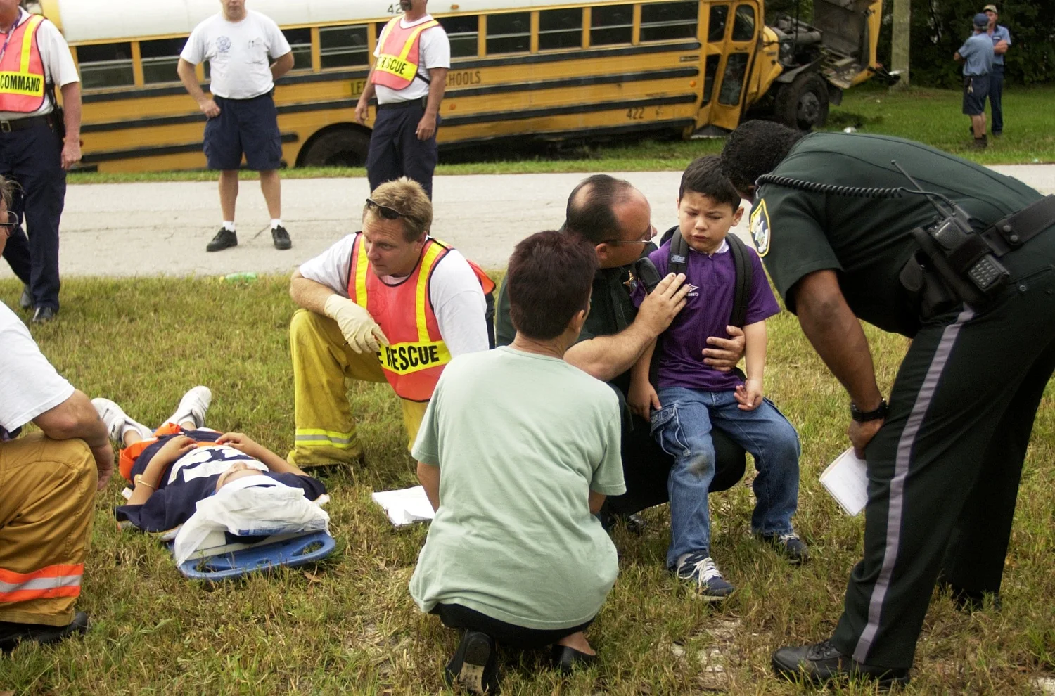  &nbsp;Lt. Blake Lee, center, and Deputy John Rodriguez, right, of the Lee County Sheriff's Office and Bonita Springs Fire-Rescue workers try to comfort two Spring Creek Elementary School students involved in a school bus crash Nine children on the b
