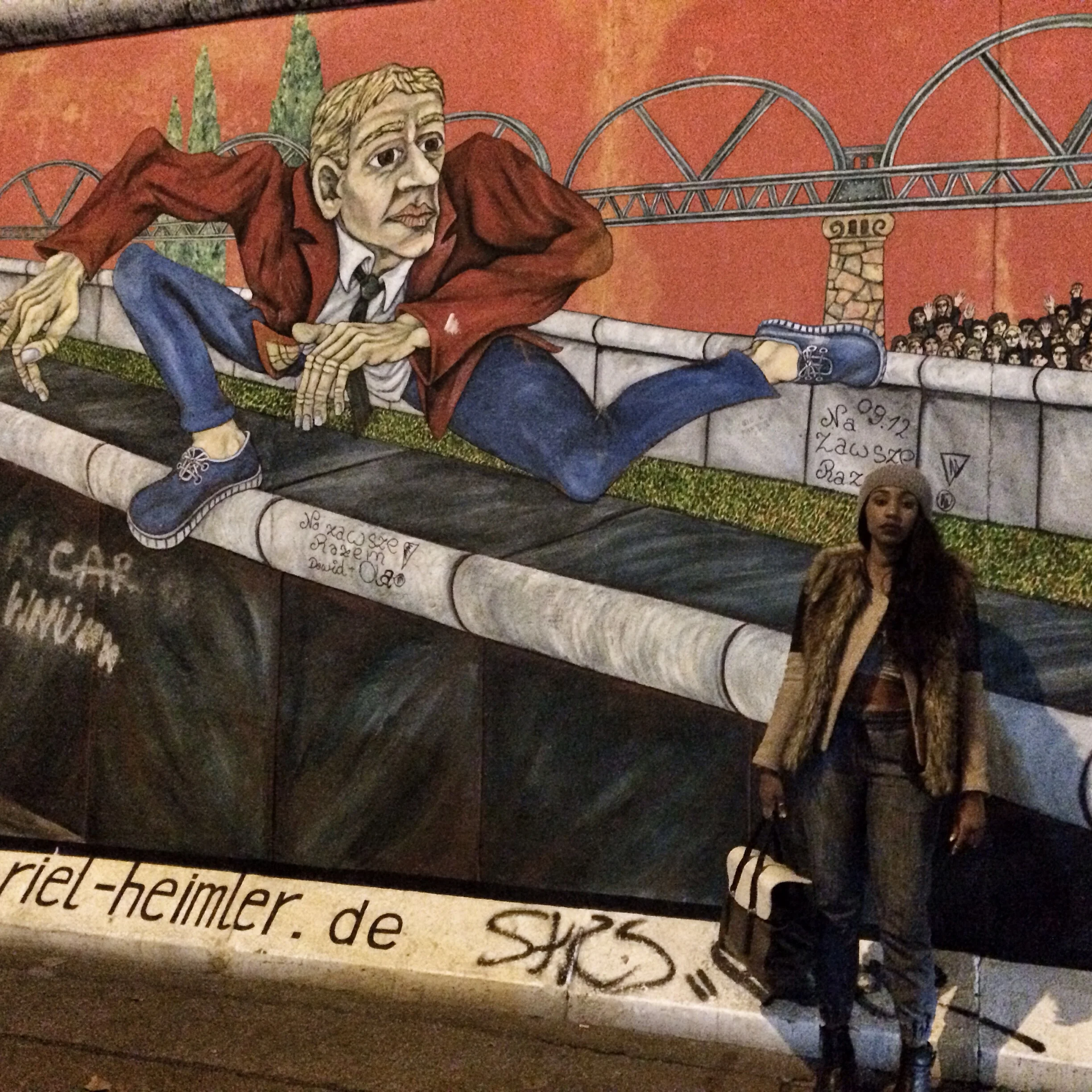 Posed in front of a part of the wall. I love the imagery. as you see a guy escaping the wall. Vivid.