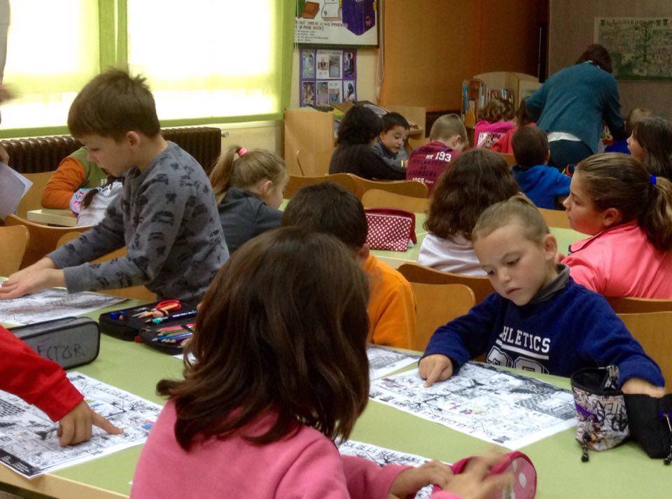 Los alumnos de primero y segundo de primaria de CRA ALTO en Cañete (Cuenca), atentos buscando personajes de literatura infantil en el póster de la Casa de la Real Gana de nuestro título, Lo que tú quieras (Una invitación a reflexionar sobre la libertad). 
