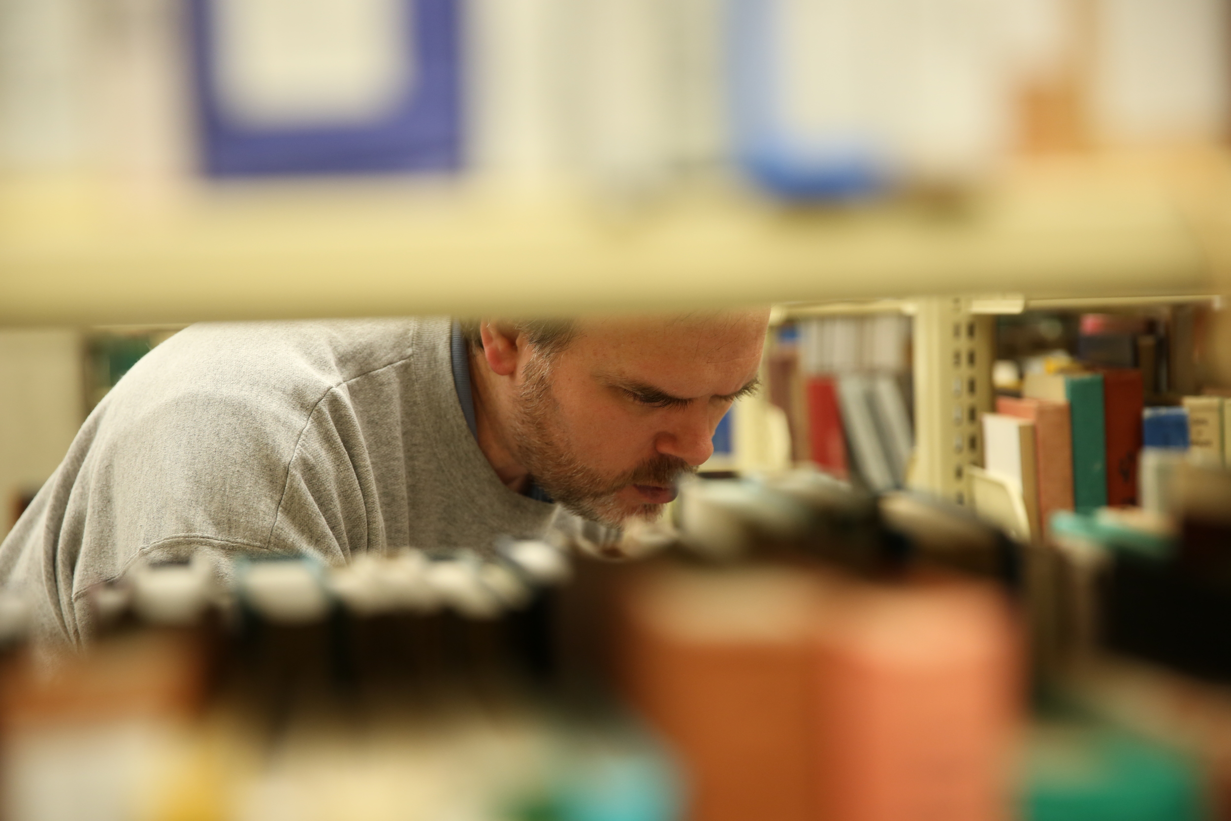 Custard searches for a requested book through the shelves of the PCL.