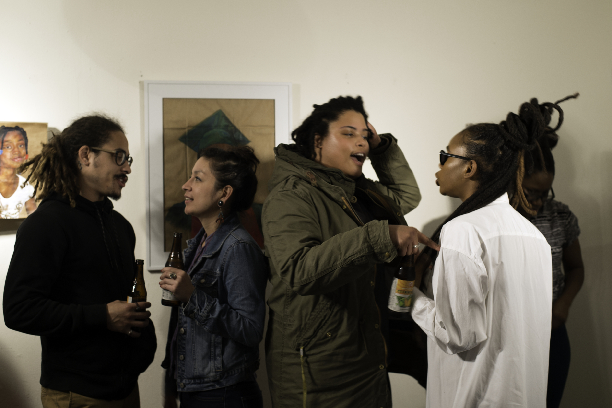Graduate student X'ene Sky Taylor (far right) near drawings of Michael Brown and Aiyana Jones.