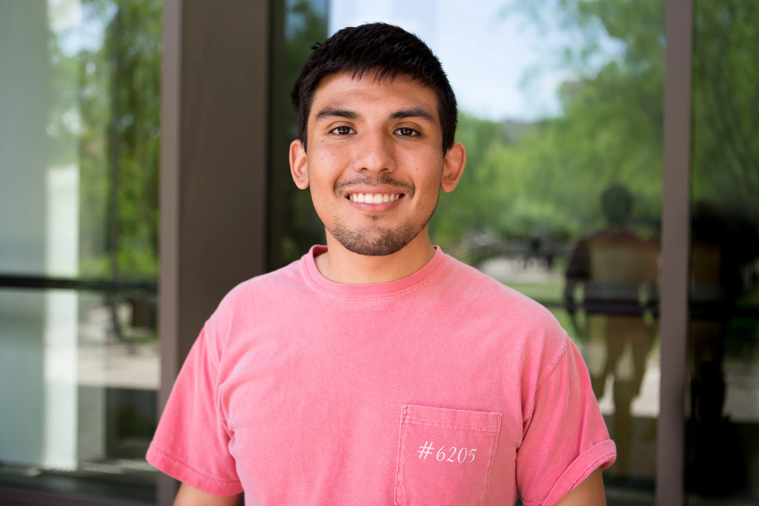 Journalism and international relations senior Zach Lozano smiles outside of the Belo Center for New Media.