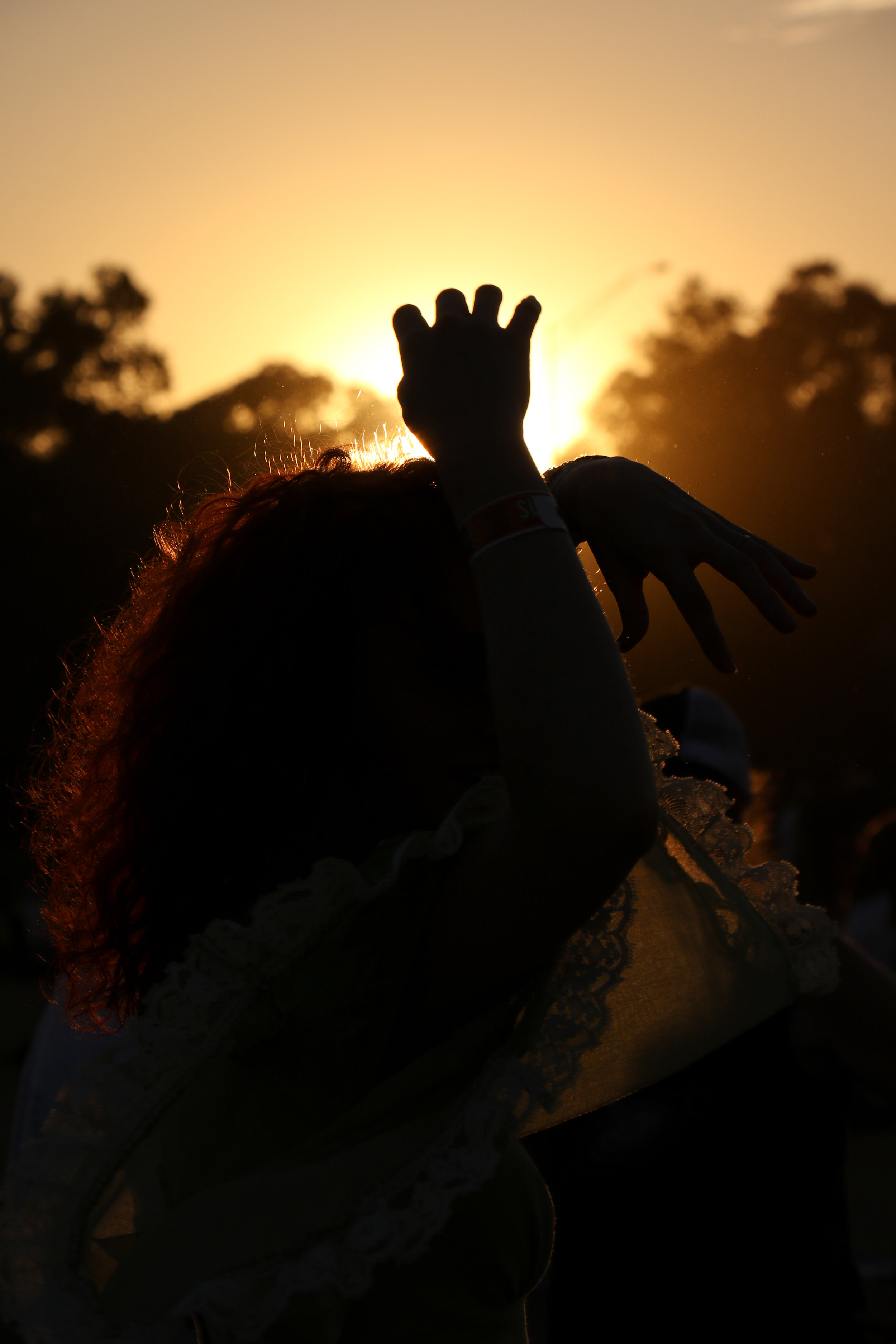 A woman dances in the sunset to one of the night’s shows.