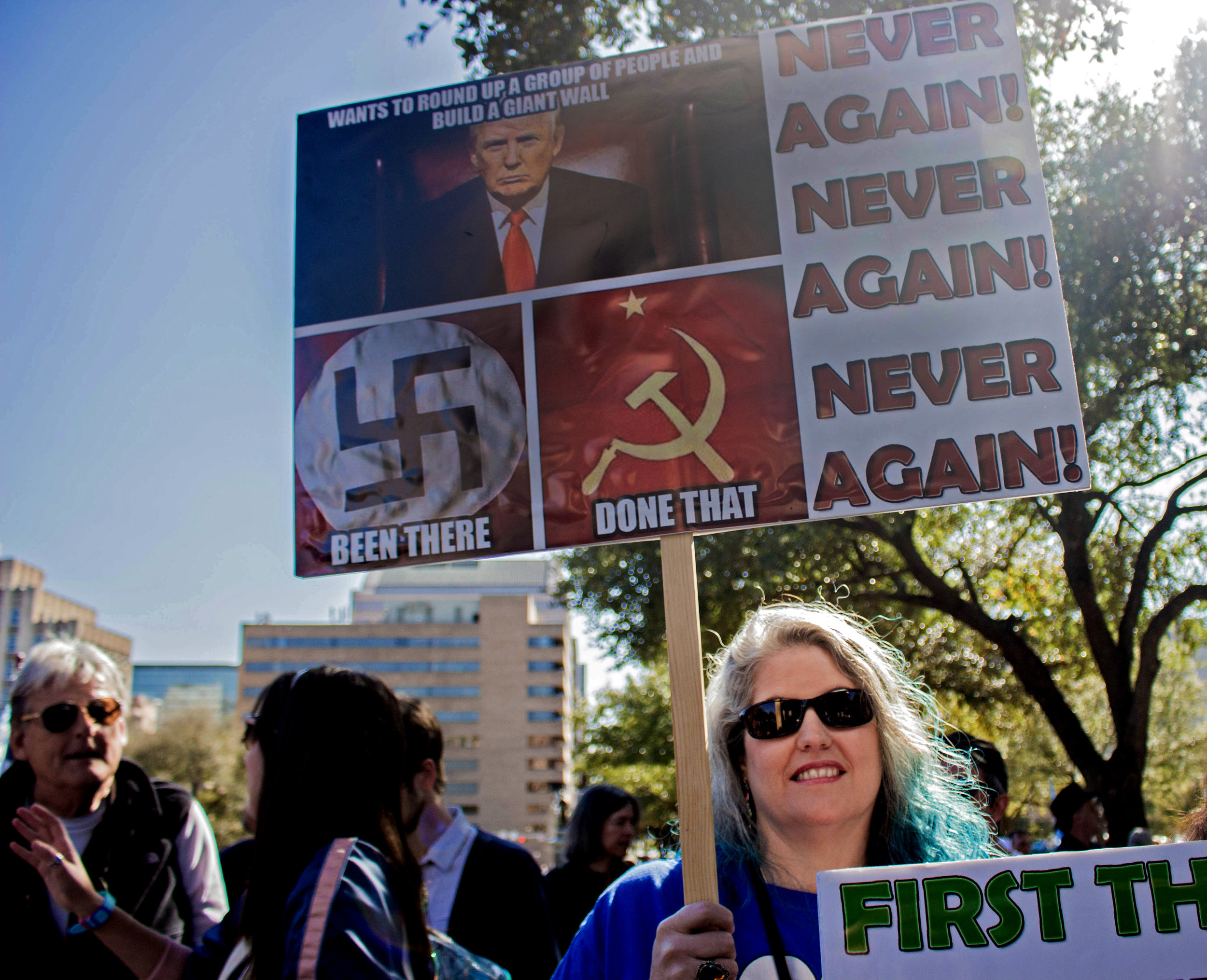 Tanya Welch holds a sign that says, "Never Again! Never Again! Never Again!" at the rally.