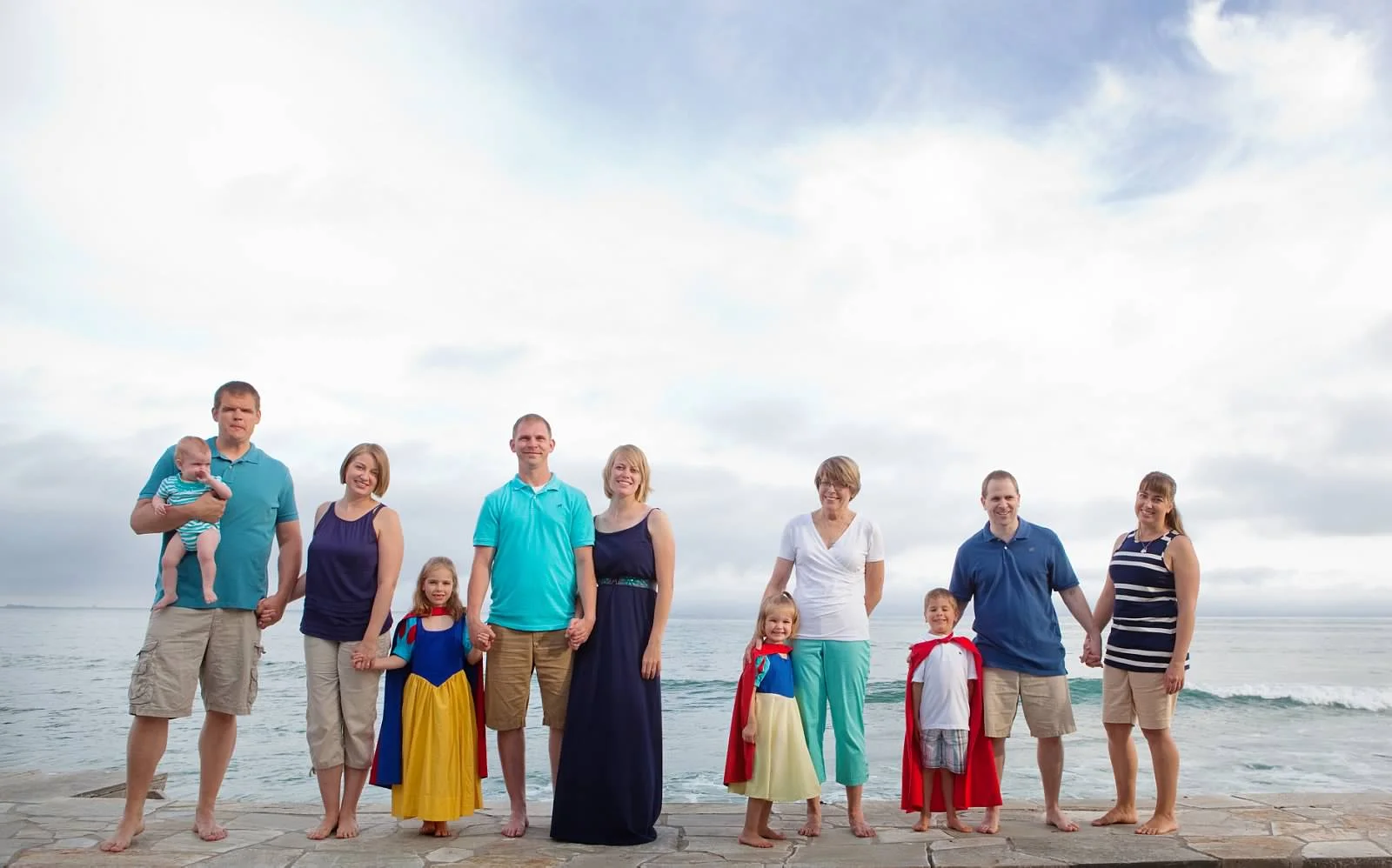 There are a million reasons why it is my favorite so I'll try to keep it to just a few for you. 1. This was literally the first time all of us (my mom, sisters, their spouses/fiance, and children had all been together and not just because the baby was young; even prior to her being born it had been years since we'd all been in the same place at one time). It represents 2 countries, 3 states within the US, thousands of miles, and probably way too many hours/phone calls from my mom to you in order to coordinate it. We don't get to see each other often and certainly not all at once so it's a joy to have a photo capturing that day. 2. I love this photo because it's not "perfect". At this point the kids were done with the matching clothes but what they are wearing in this photo is truly "them". 3. My favorite part is the space between my sister in the blue dress and my mom/daughter. Why? Because it's exactly where my dad would have been if he had lived to meet his grandkids and join us for this photo. The space wasn't intentional, truthfully I looked at this picture 1000 times (it's in a place where I see it multiple times per day) before I noticed the space, but it is the perfect spot for him. Maybe he's there and we just can't see him.