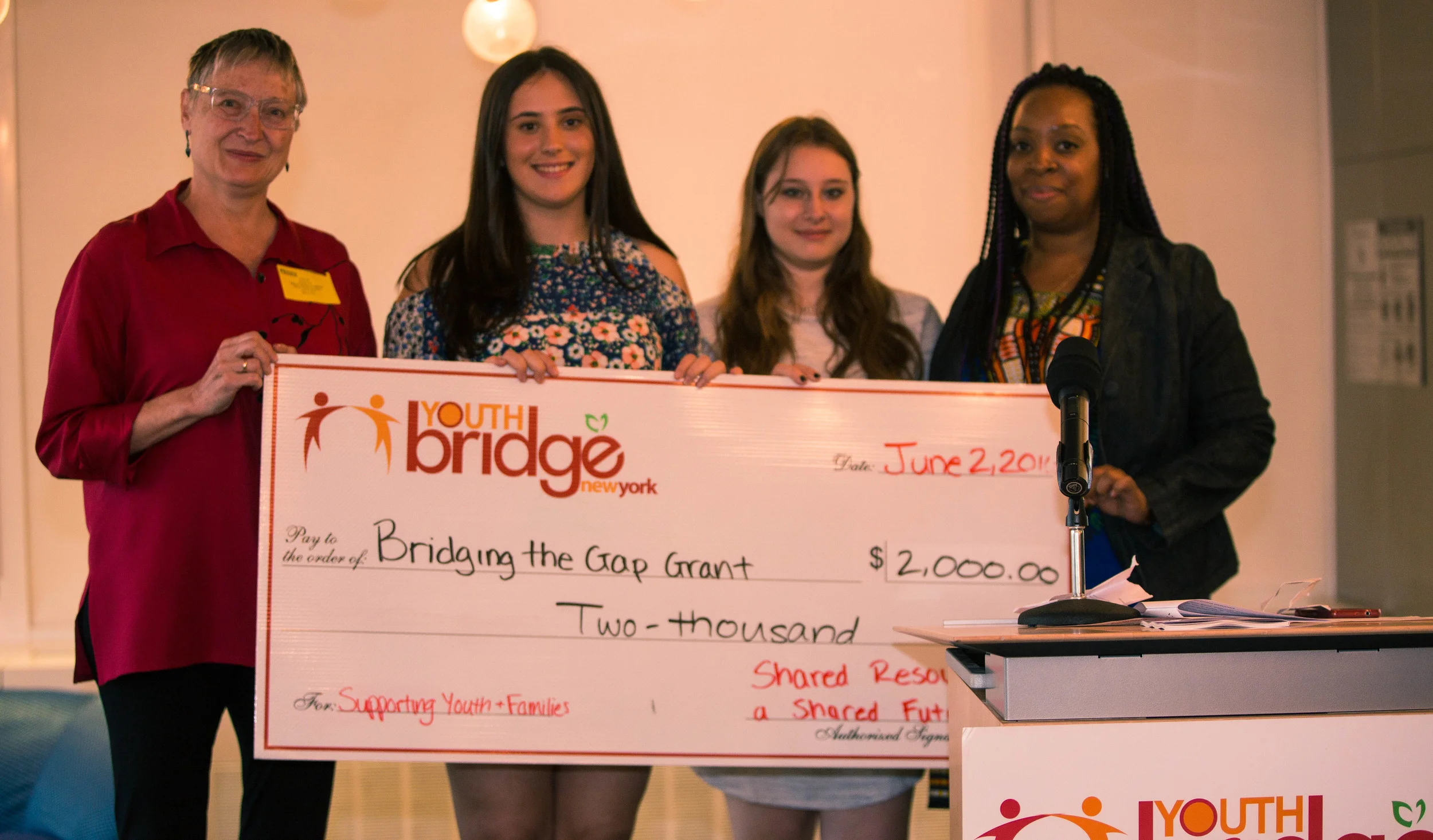 Molly and Sam, members of the Shared Resources for a Shared Future Committee, presenting this year's grant to our worthy grant winners.