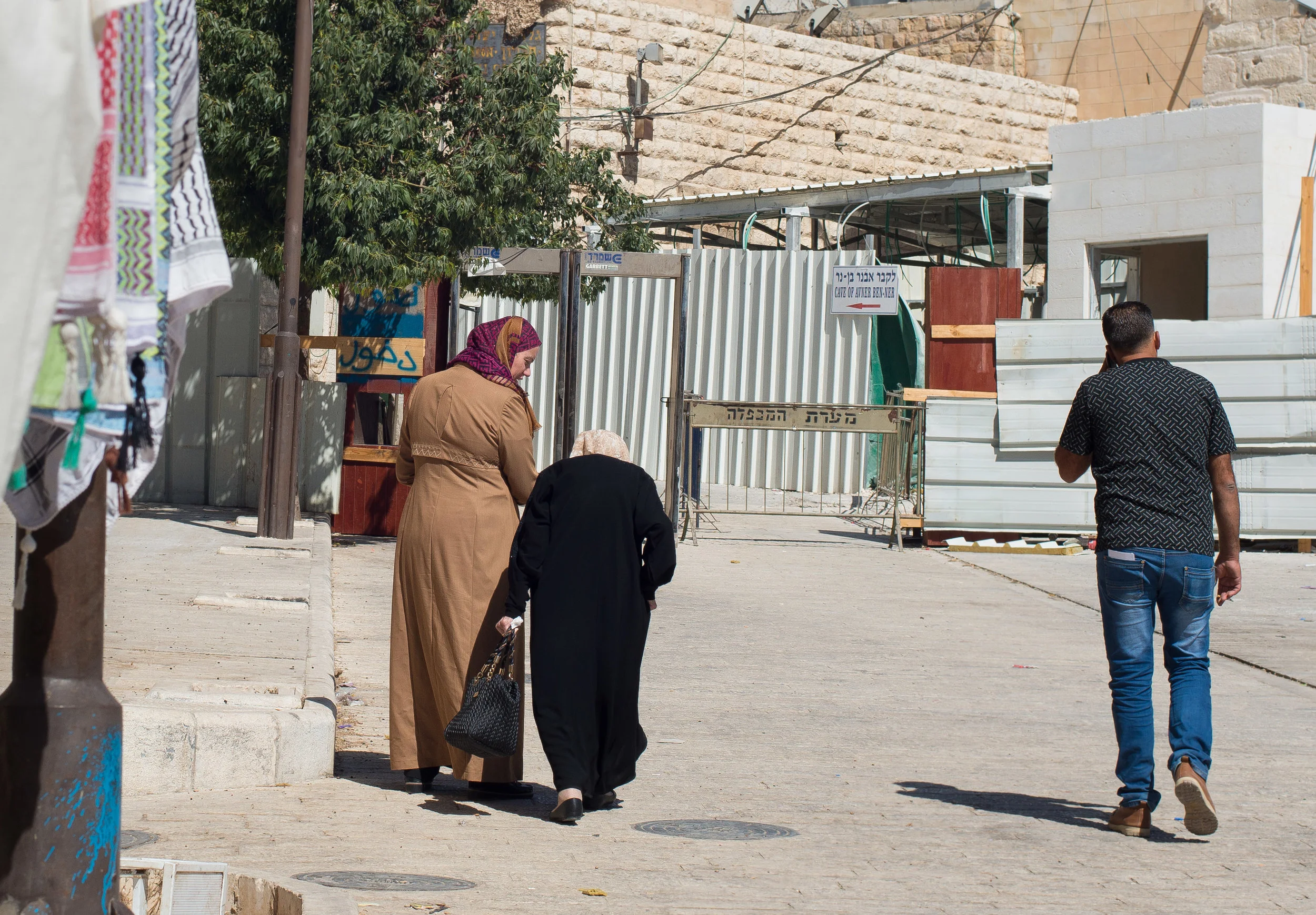 Palestinians walk toward the checkpoint directly on the other side of the Ibrahimi Mosque, just meters from another checkpoint. Old City Hebron (H2), West Bank, Palestine.