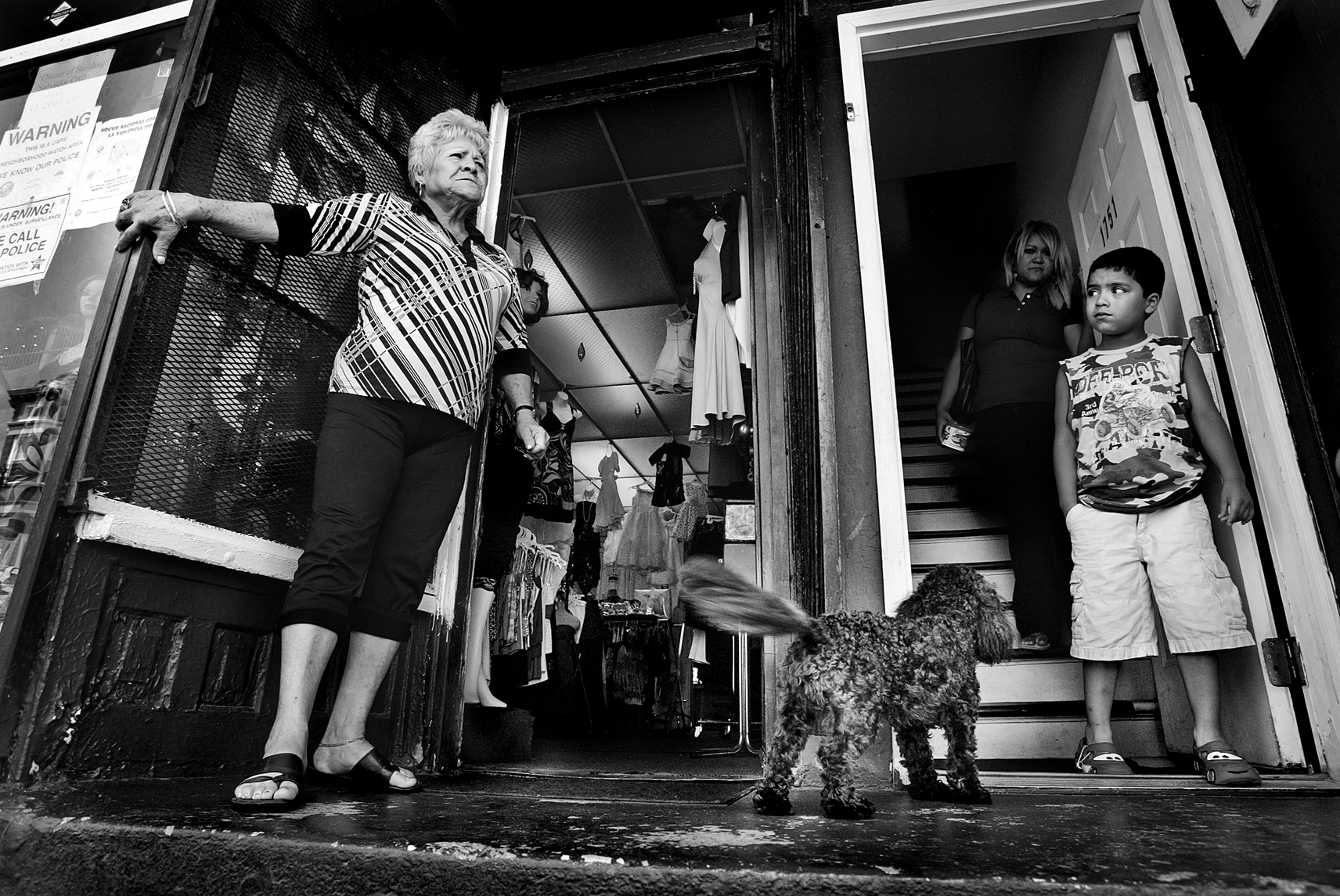 A shop owner sharing a building with apartment dwellers, yells across the street in the Latino neighborhood in Chicago.