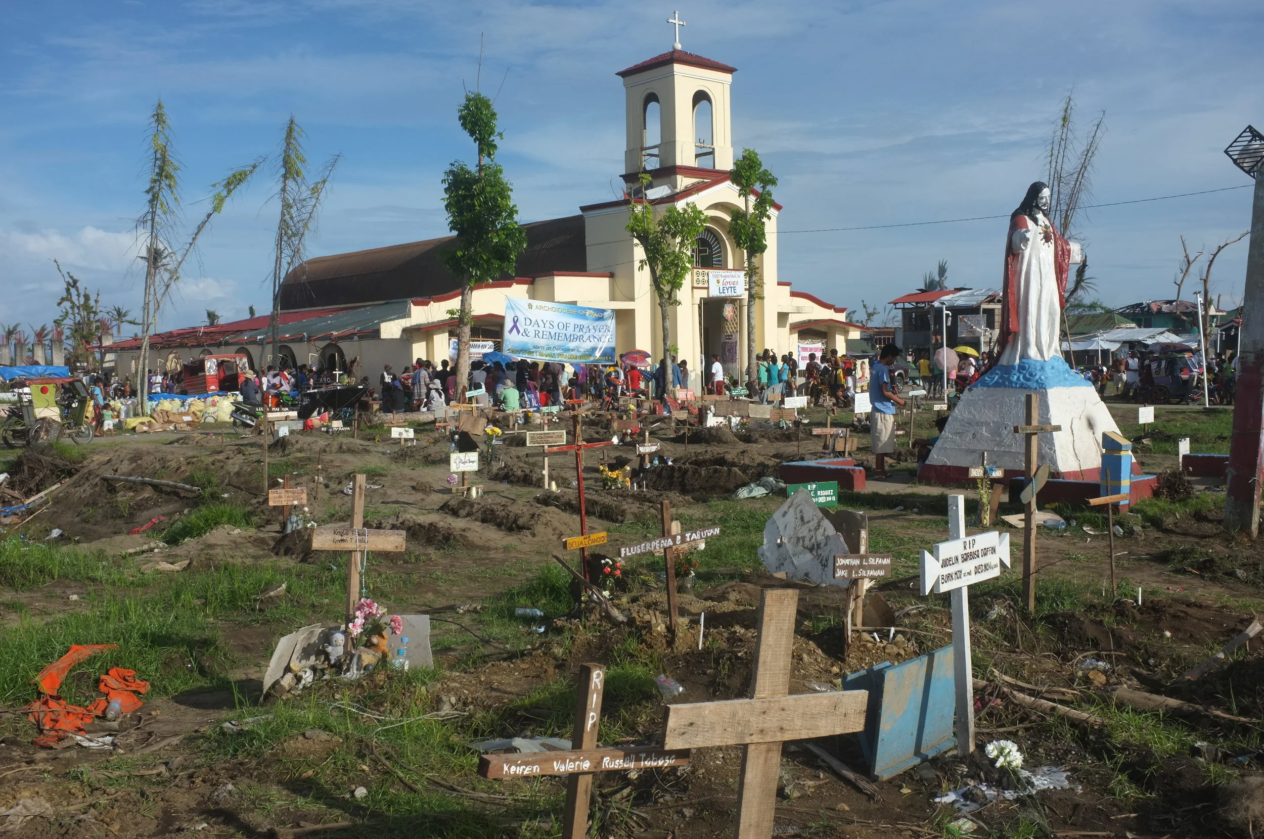  December 2013 | Tacloban, Philippines: Outside a Catholic Church where people started to bury their loved ones after Typhoon Haiyan made landfall. Some of the graves had 3-4 people buried in one spot.  