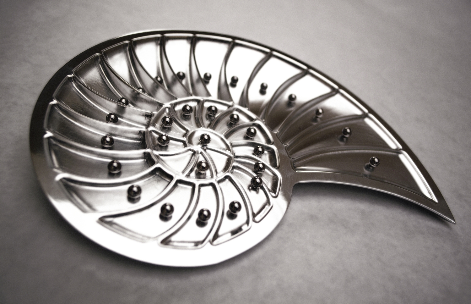 The Nautilus is a table-top monthly goal tracker. CNC Machined out of 6061 Aluminum with steel balls and neodymium magnets A user places a steel ball for each day of the month in each consequent slot when accomplishing a goal that day, an empty slot represents not achieving that goal. 