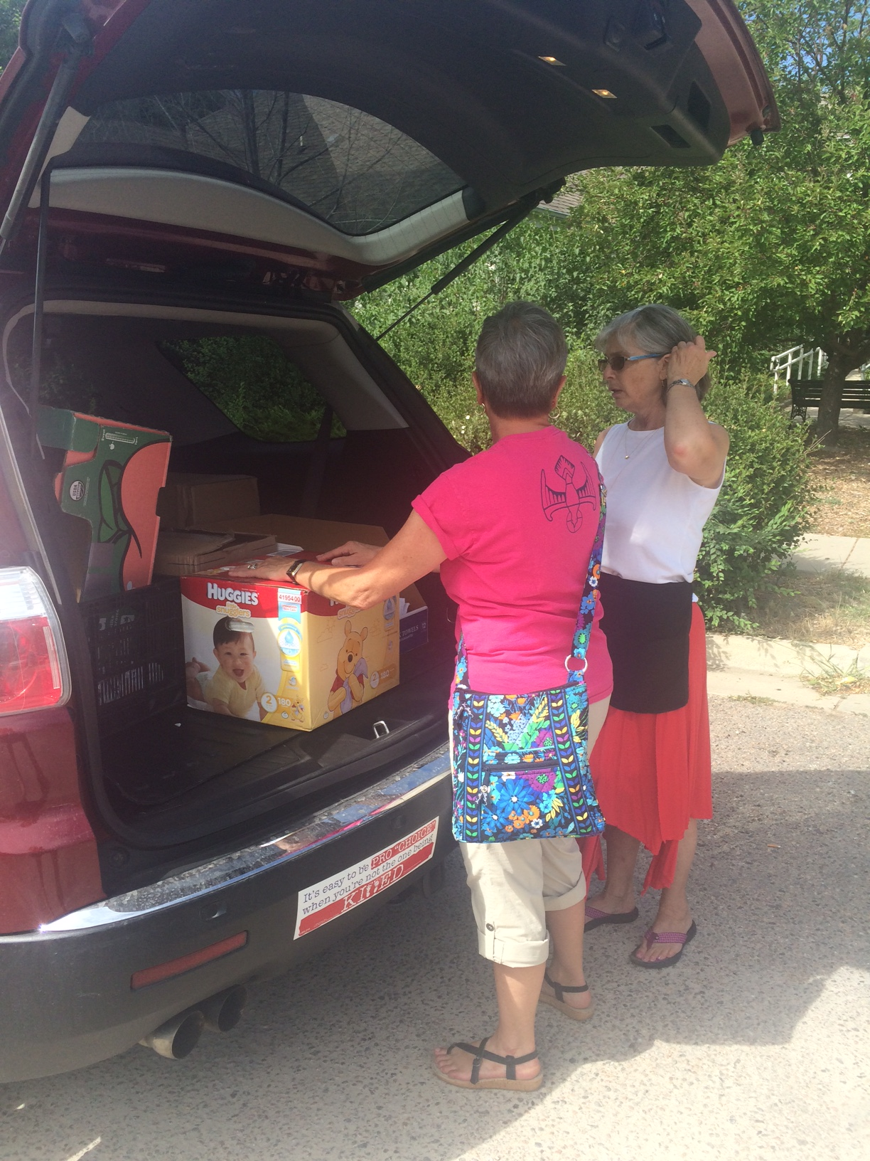 One of our wonderful volunteers, who prefers to remain anonymous, helps staff member Nancy Ott carry in a carload of household goods. 