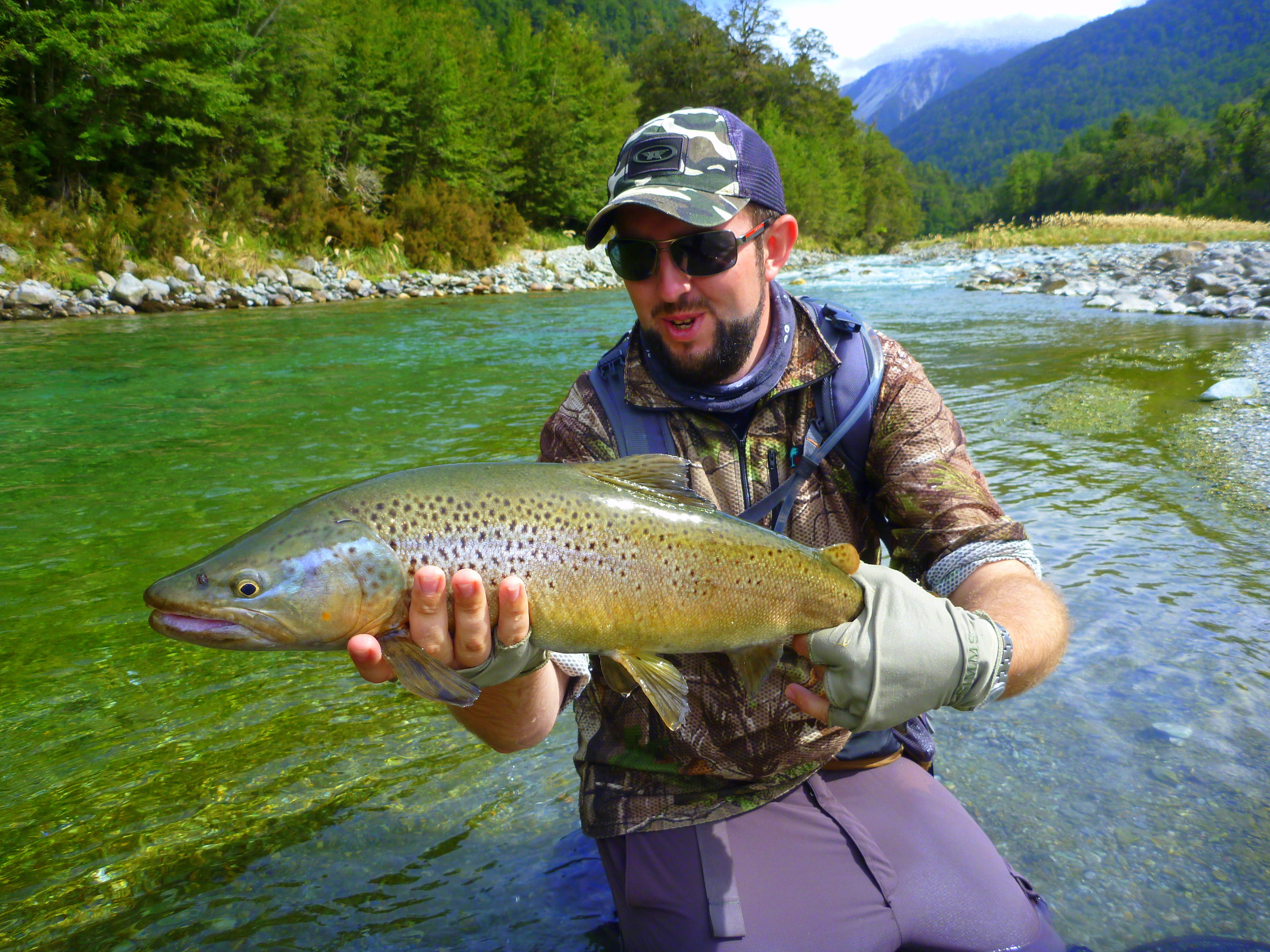 Client holding a trophy brown trout from the Cascade river in the Haast region South Westland of the South Island of New Zealand.