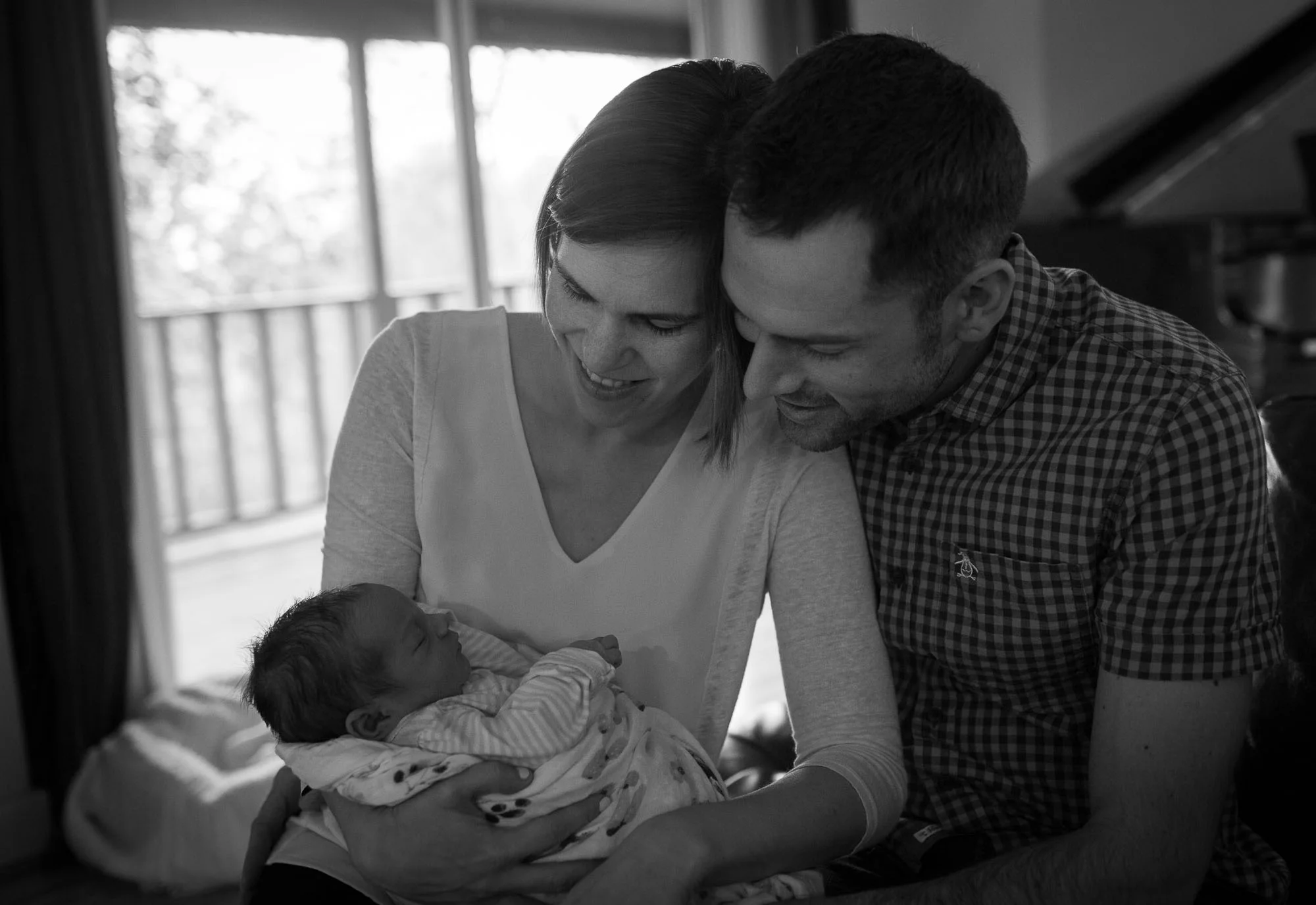 Mom and dad admiring the new baby. Austin newborn photography.
