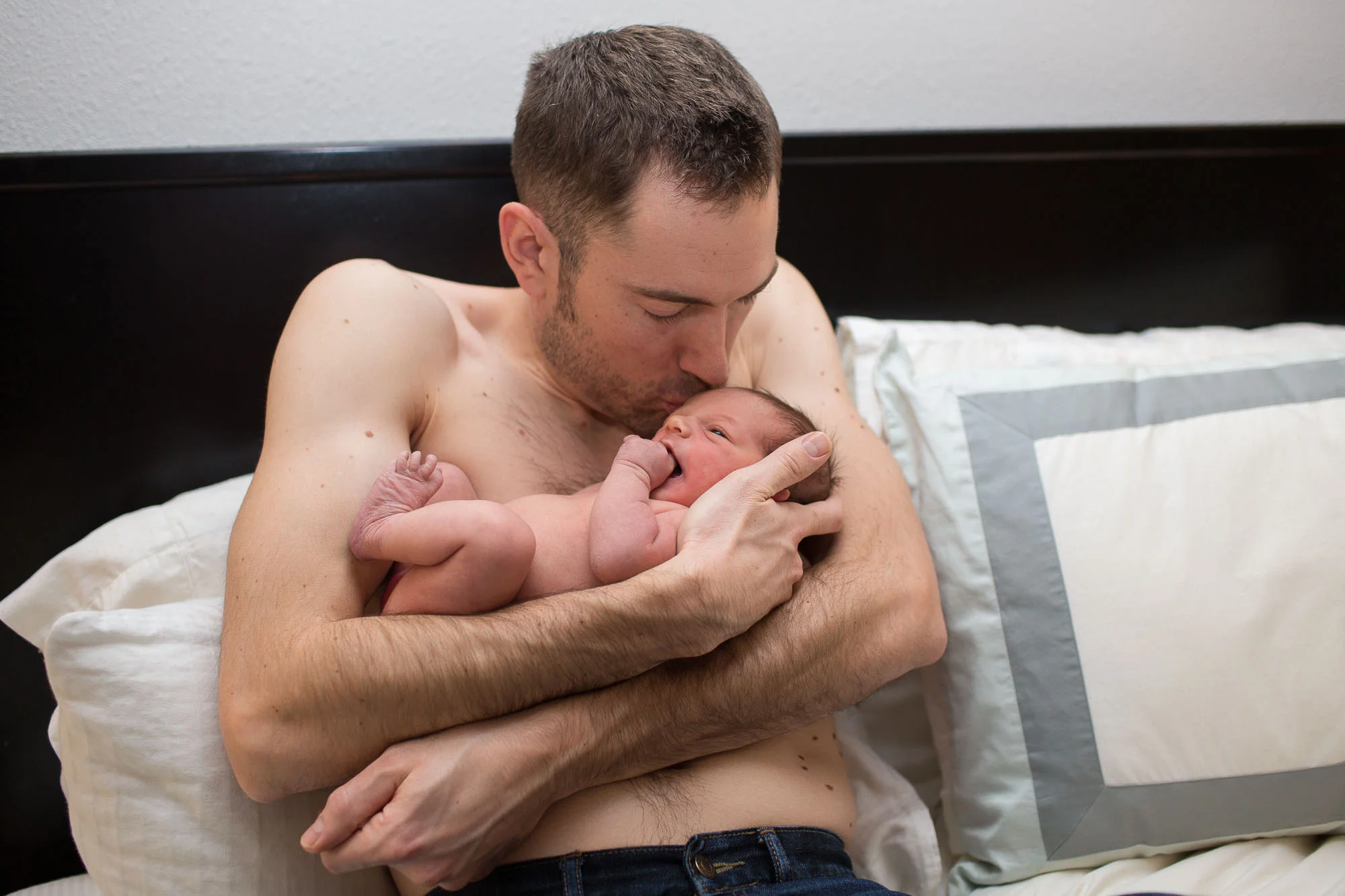 Stuart holding and kissing baby Helen. Austin newborn photography.