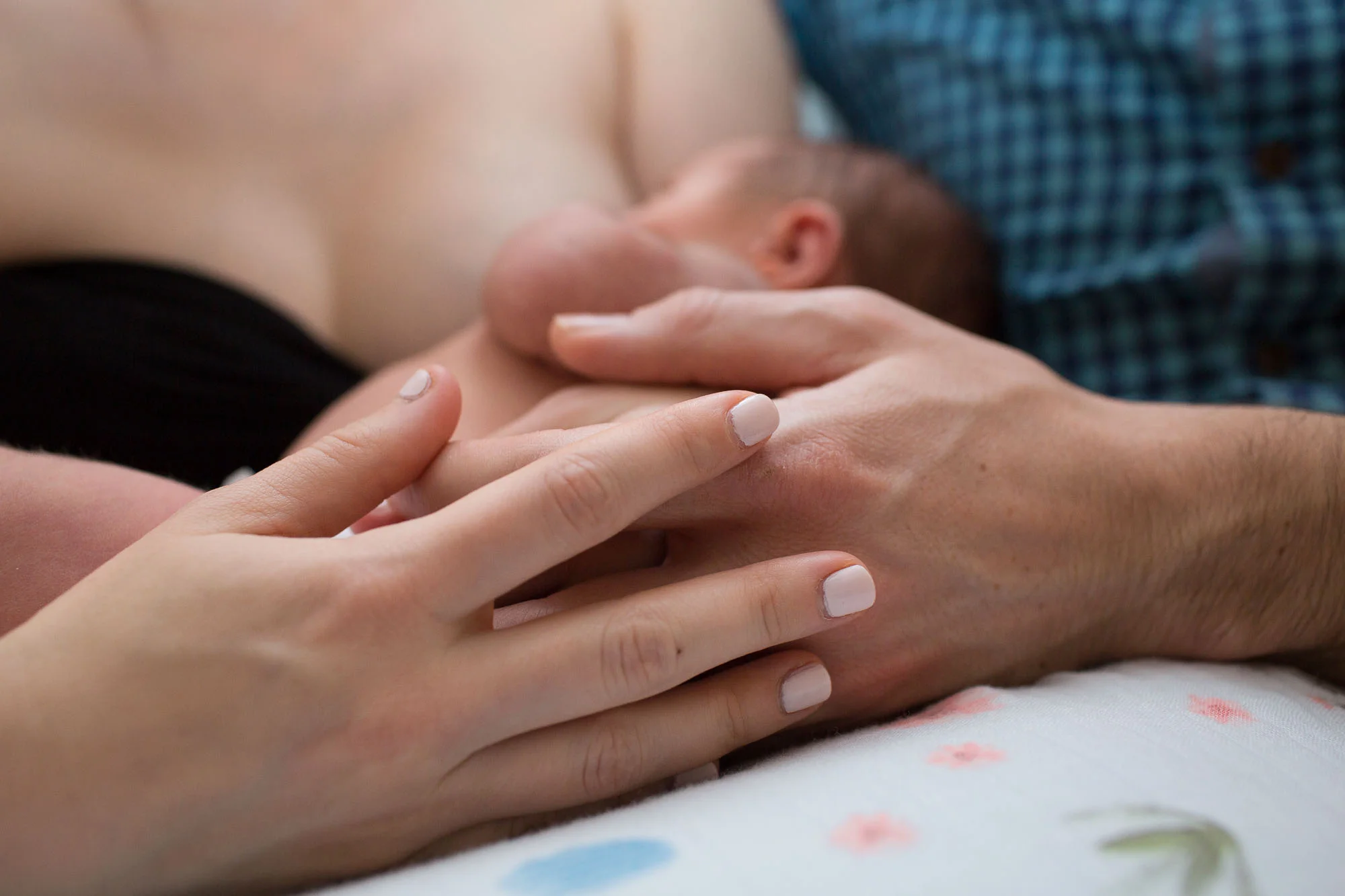 Hands of love wrapped around nursing baby. Austin newborn photography.