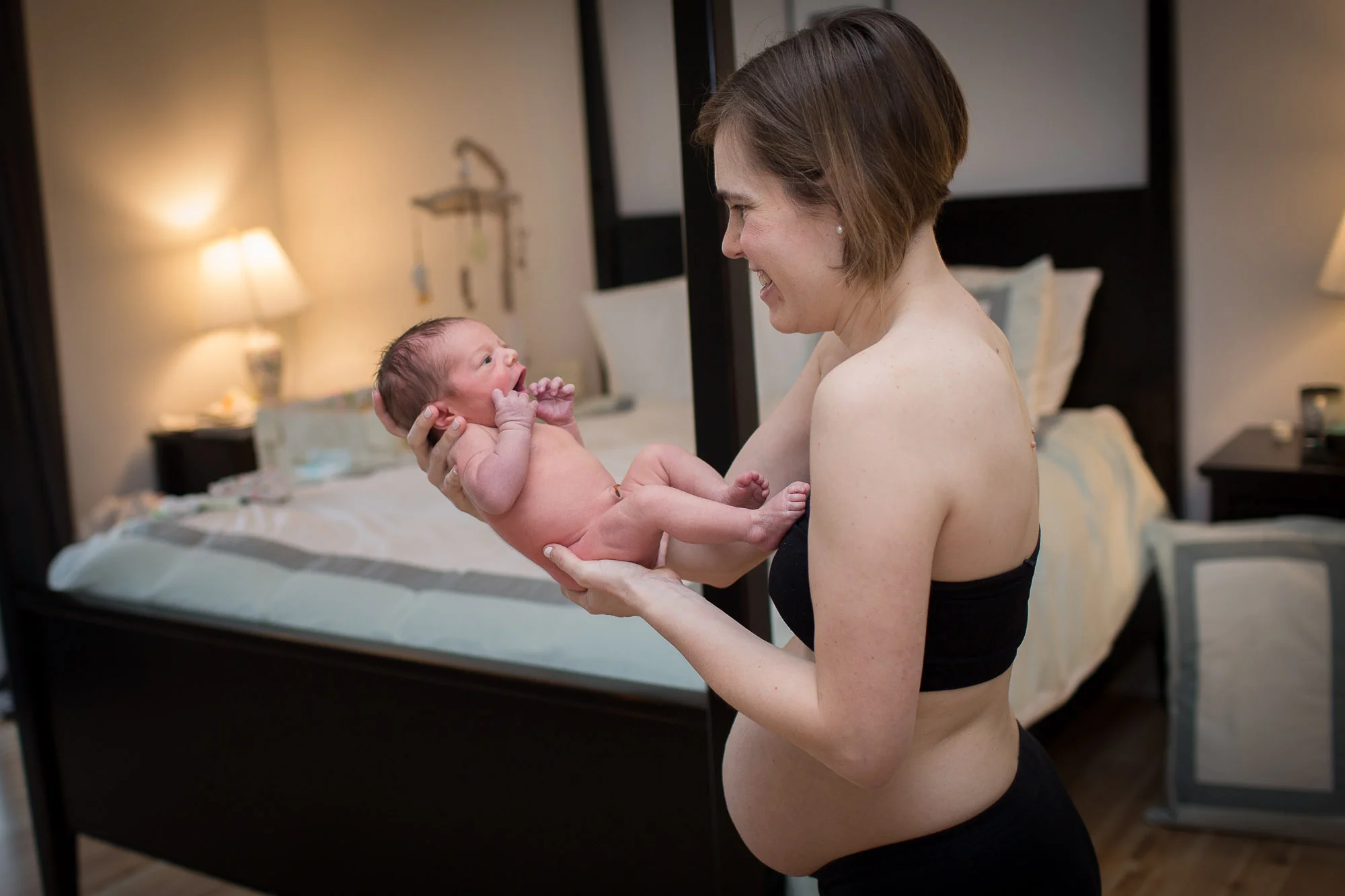 Keris hold baby Helen, showing postpartum belly. Austin in-home baby photographer.