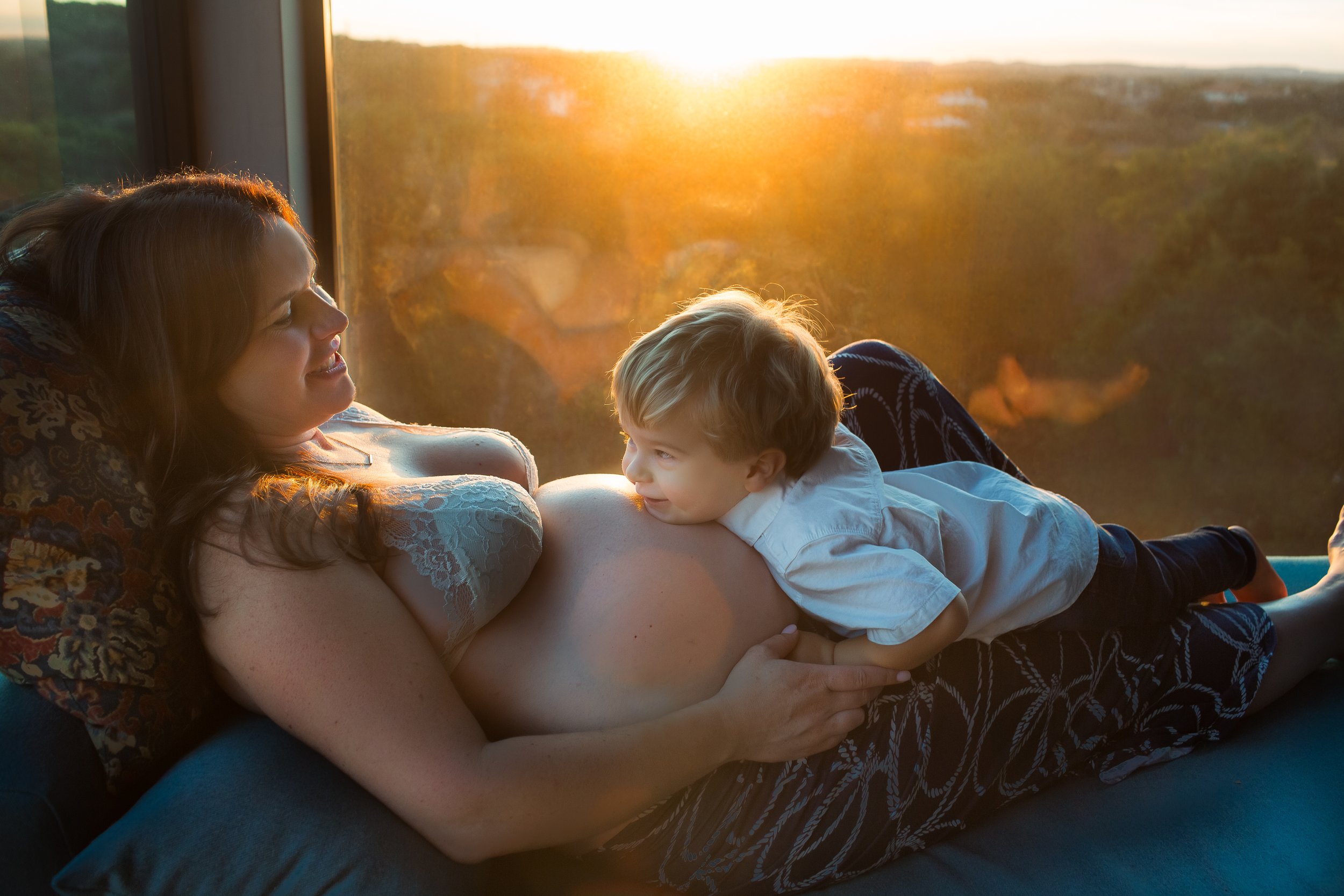  Pregnant mother reclining with toddler boy laying his head on her belly: Austin maternity photographer 