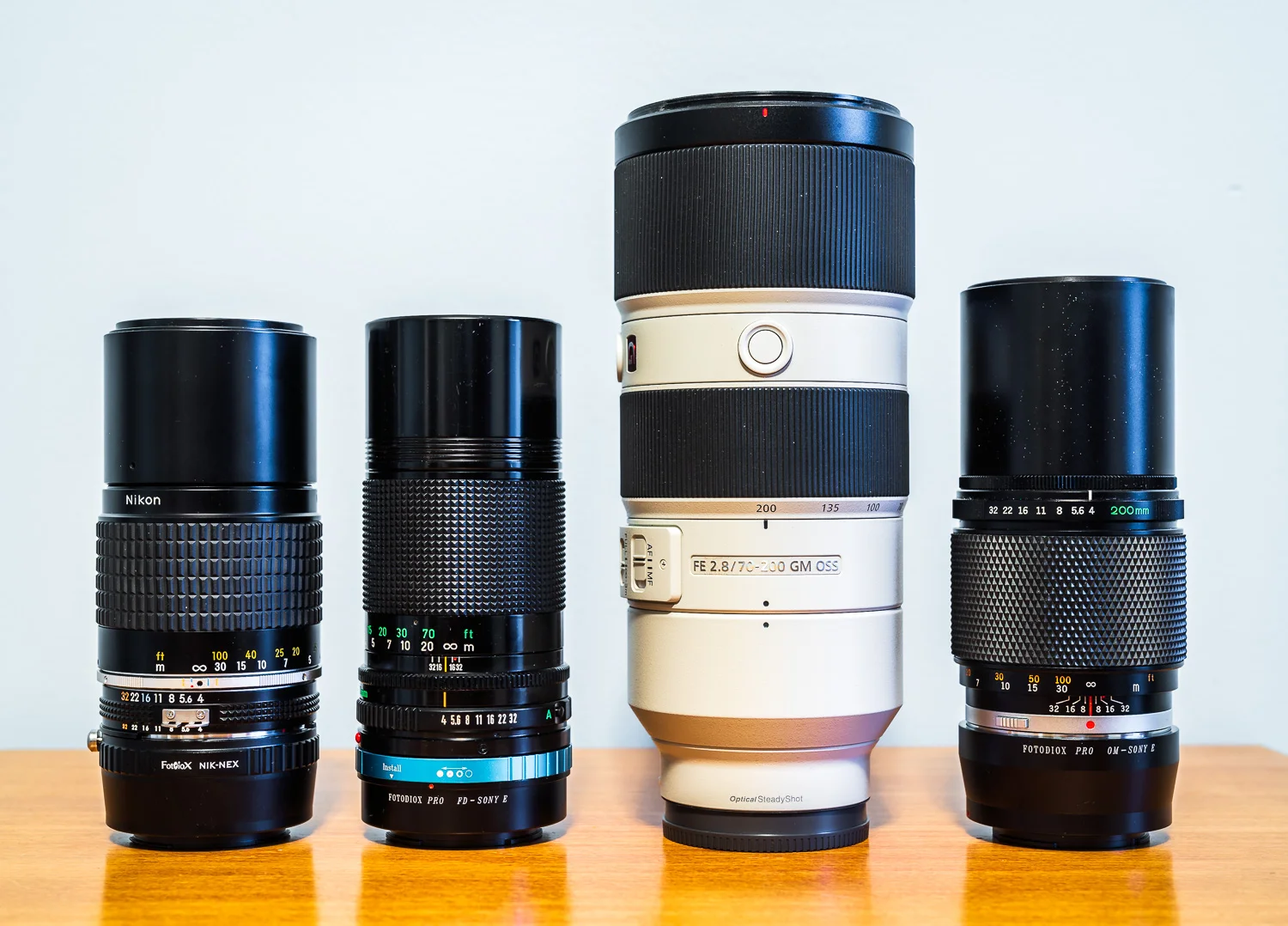 From left to right: Nikon Ai-s Nikkor 200mm f/4 (1.38 lbs), Canon new FD 200mm f/4 (1.20 lbs), Sony 70-200 f/2.8 GM (3.26 lbs), and Olympus OM Zuiko MC Auto-T 200mm f/4 (1.35 lbs)