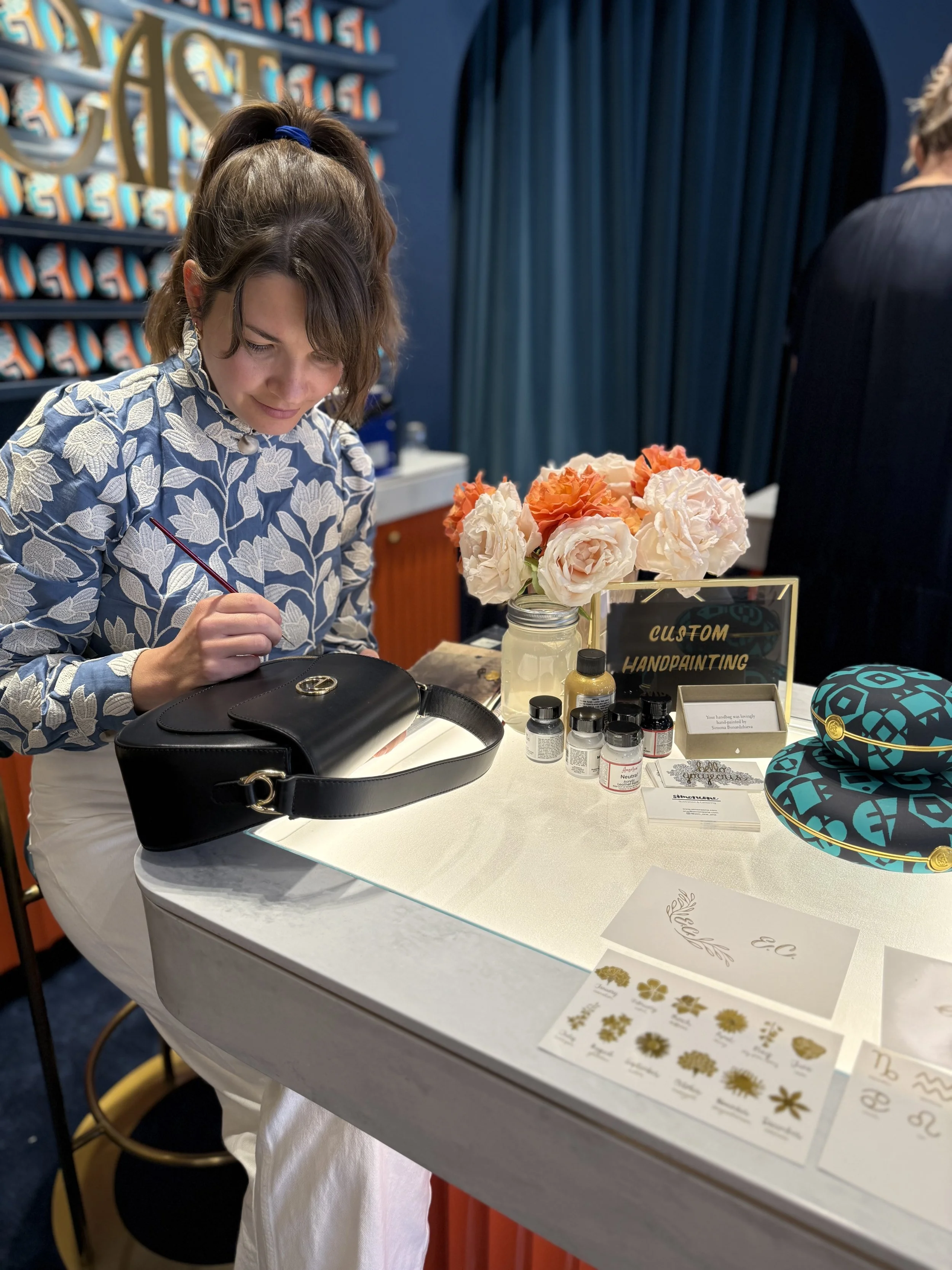 artist hand painting a leather bag