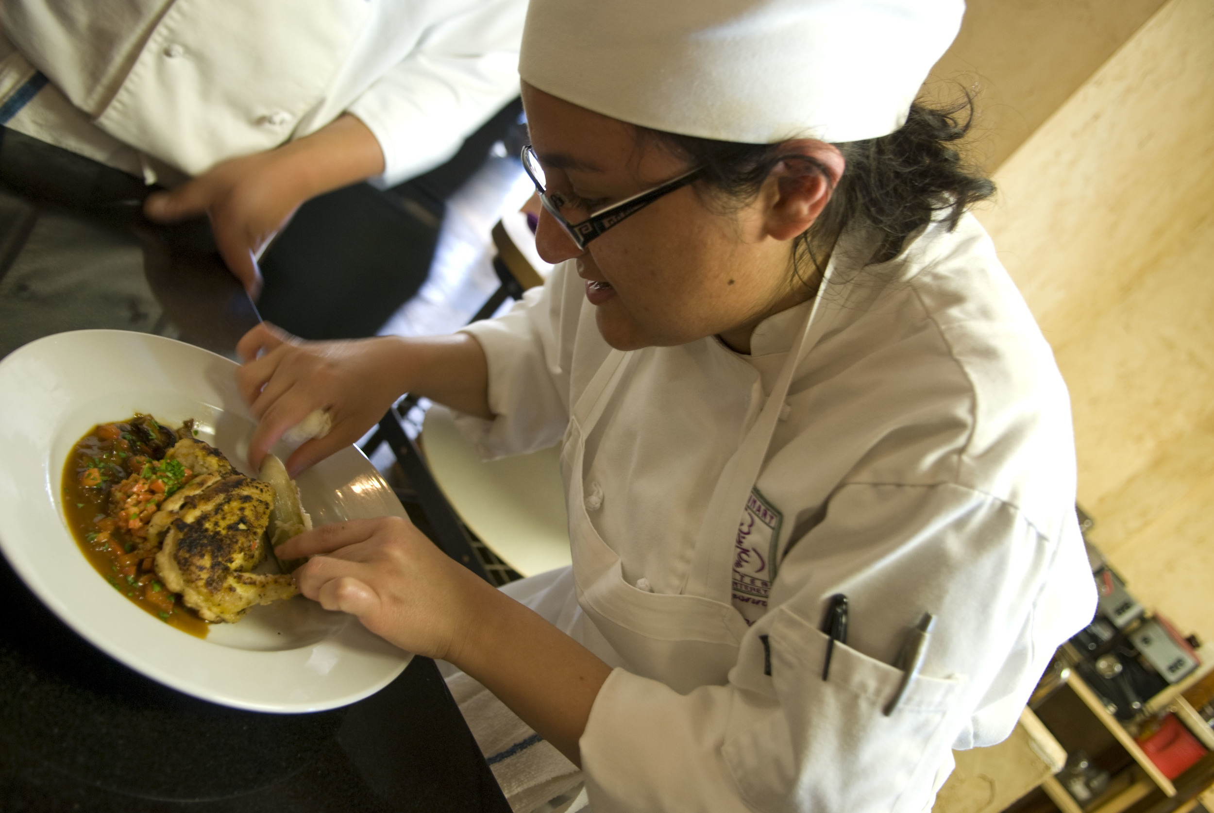  Student Nina Justamonte of the Culinary Centre of Monterey adds the finishing touches to a game hen on 20 March 2008. 