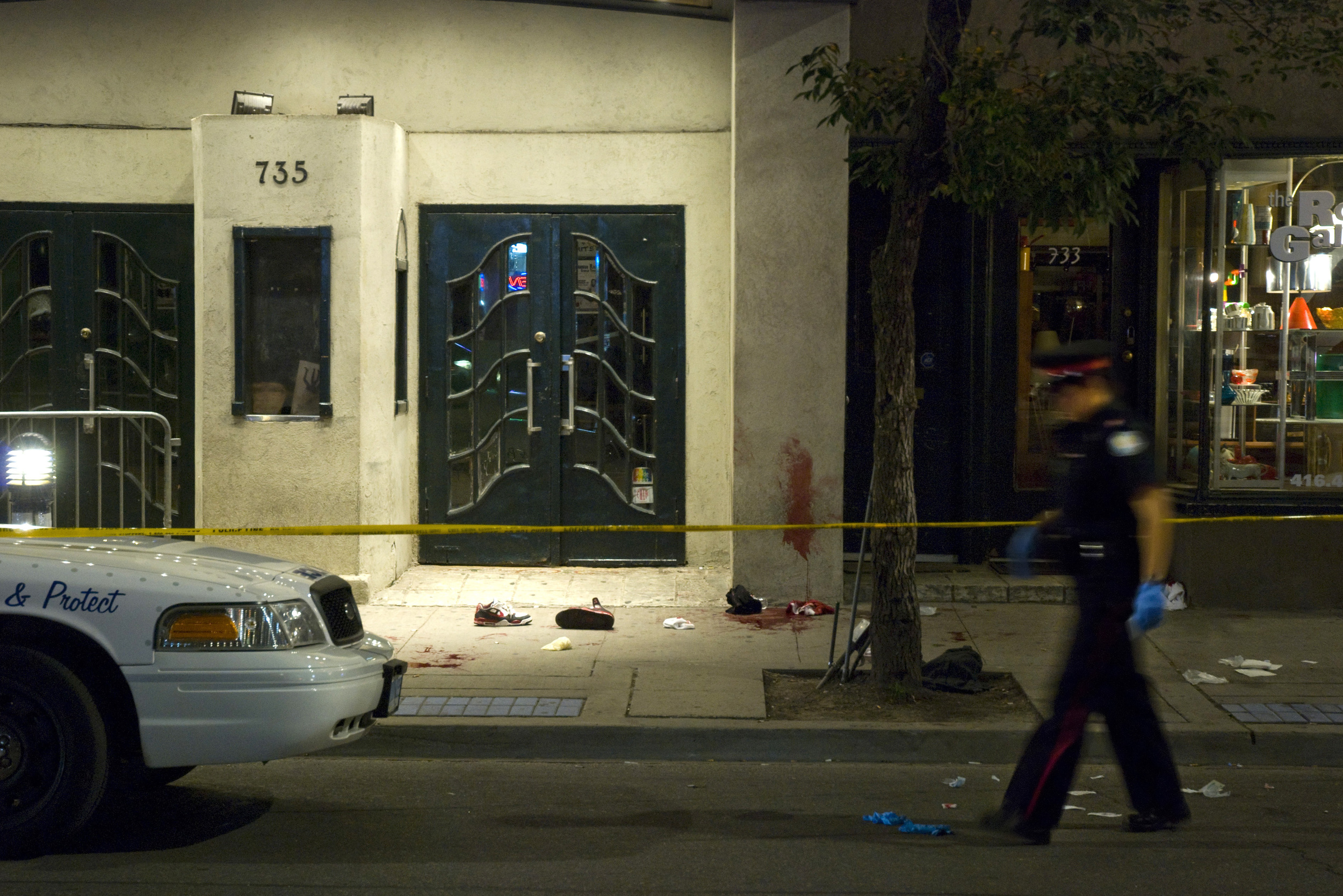  A Toronto Police Service officer walks past the scene of a stabbing which occurred outside the Opera House concert hall at Broadview and Queen West on August 6, 2009.&nbsp; Two men were taken to the hospital with serious injuries. 