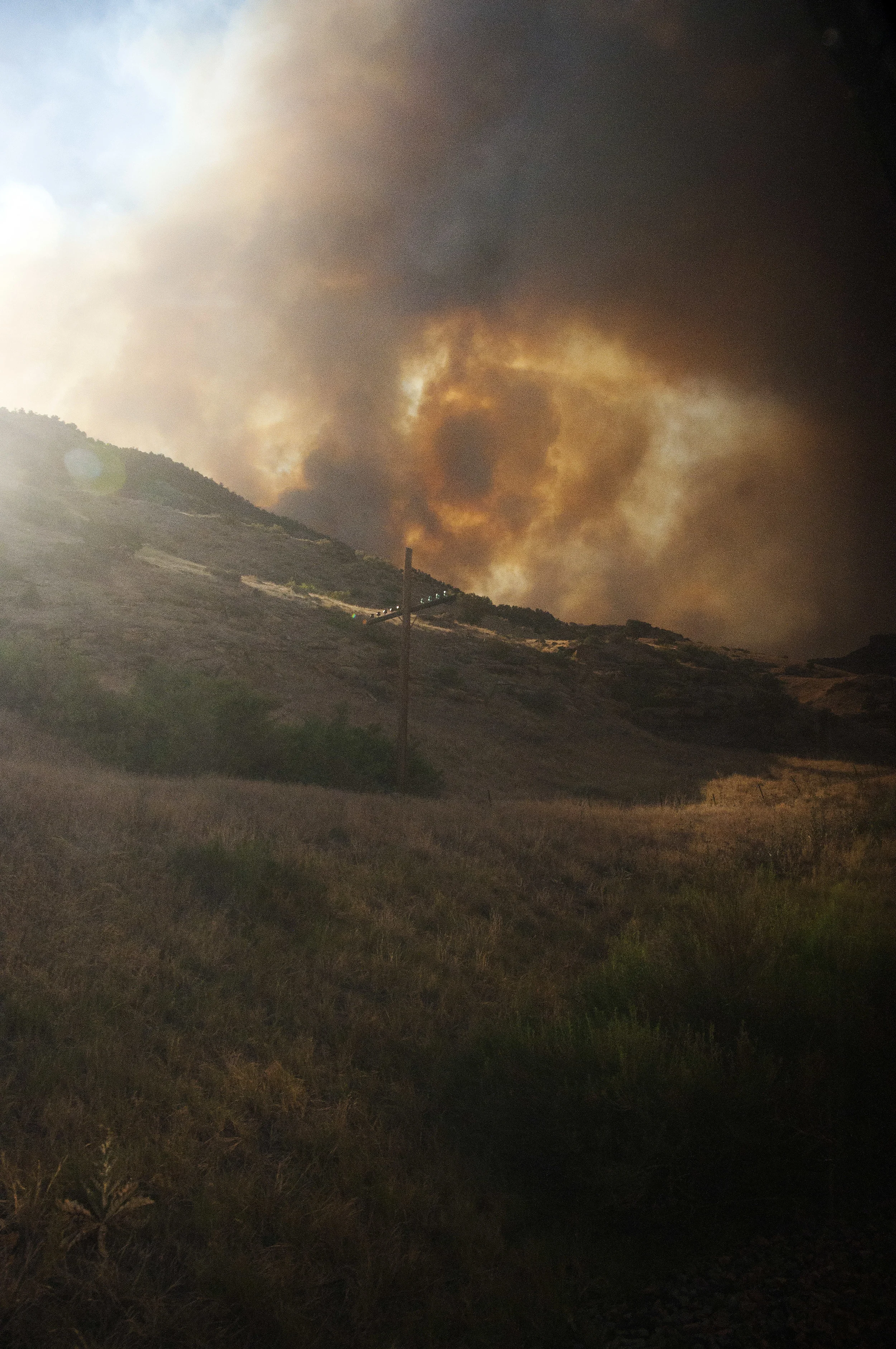 The Pine Ridge fire burns down into De Beque Canyon near Grand Junction, CO on 28 June 2012. The fire, seen here from an Amtrak train, shut down both the railway line and Interstate 70 for hours until the wind pushed it back atop the surrounding mesa.