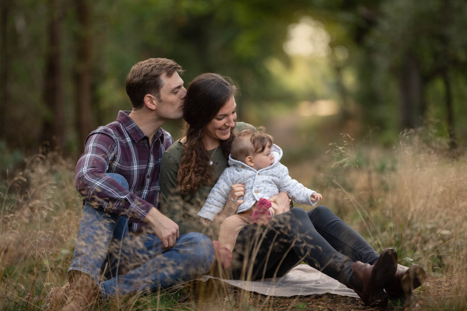 family photographer reading mum and dad with baby