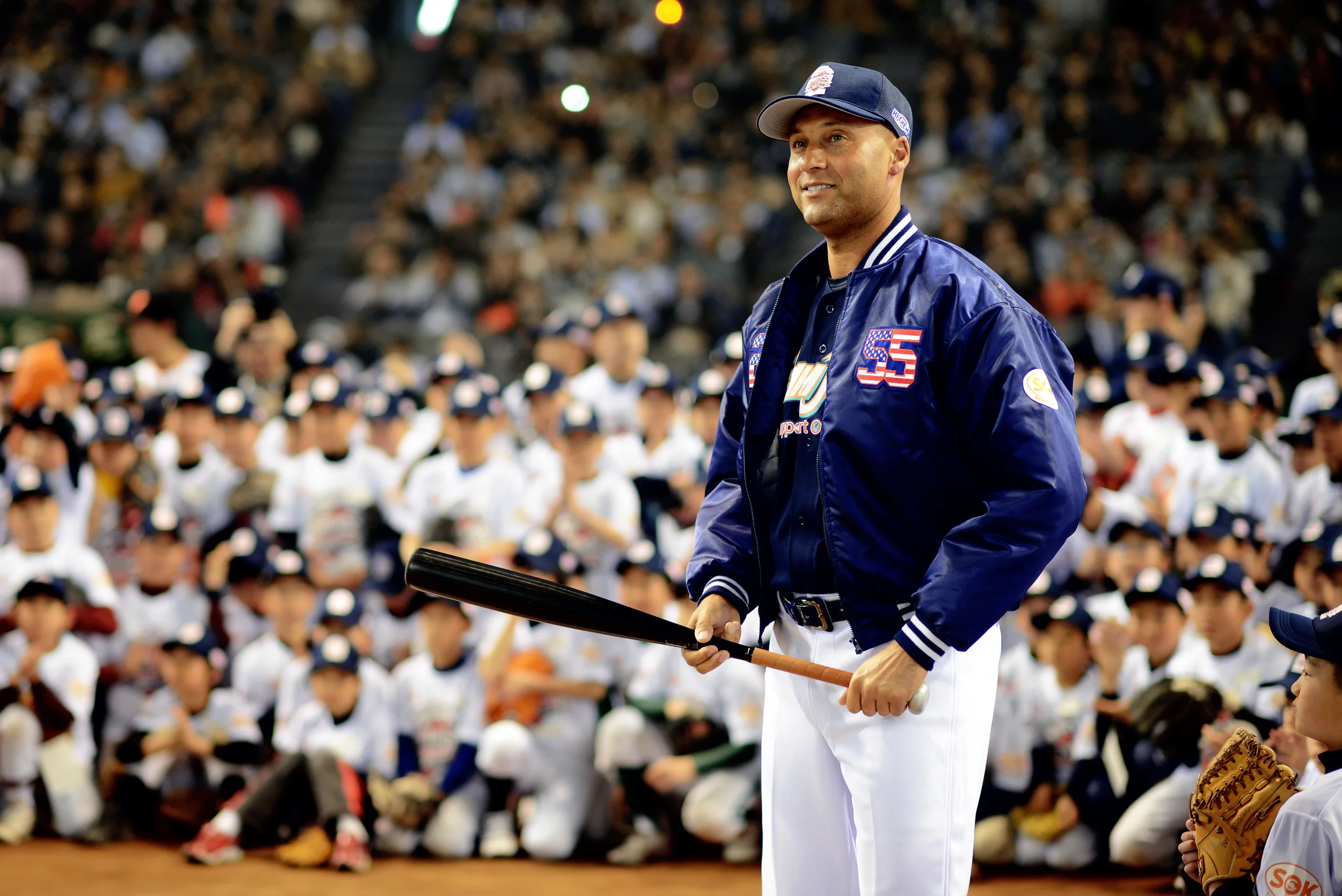 Derek Jeter, retired New York Yankees baseball player, demonstrates how to hit a baseball for Japanese and American children during the Tomodachi Charity Baseball Game, March 21, 2015, at the Tokyo Dome, Japan. Jeter teamed up with former Yankee Hideki Matsui to support survivors of the 2011 earthquake and tsunami in northeastern Japan. (U.S. Air Force photo by Airman 1st Class Delano Scott/Released)