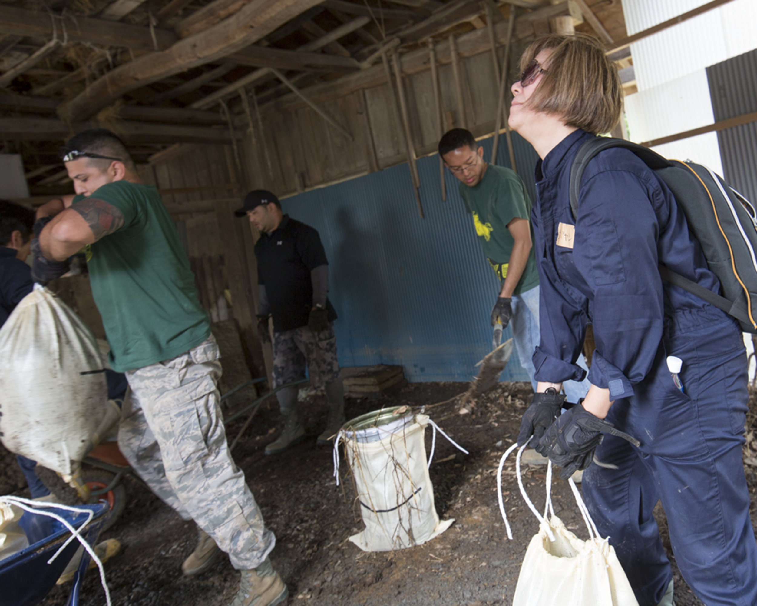Volunteers from the 374th Civil Engineer Squadron carry bags full of mud from a house at Kanuma City, Tochigi Prefecture, Japan, Sept. 15, 2015. Sixty Airmen and civilians from the 374th CES volunteered to help at sites in the Kasono area in support of floods and landslides caused by the heavy rainfall associated with the post-tropical remnant of Tropical Storm Etau, which stalled over eastern Japan, dumping up to 17 inches of rain in 24 hours, from Sept. 10 to Sept. 11. (U.S. Air Force photo by Osakabe Yasuo/Released)