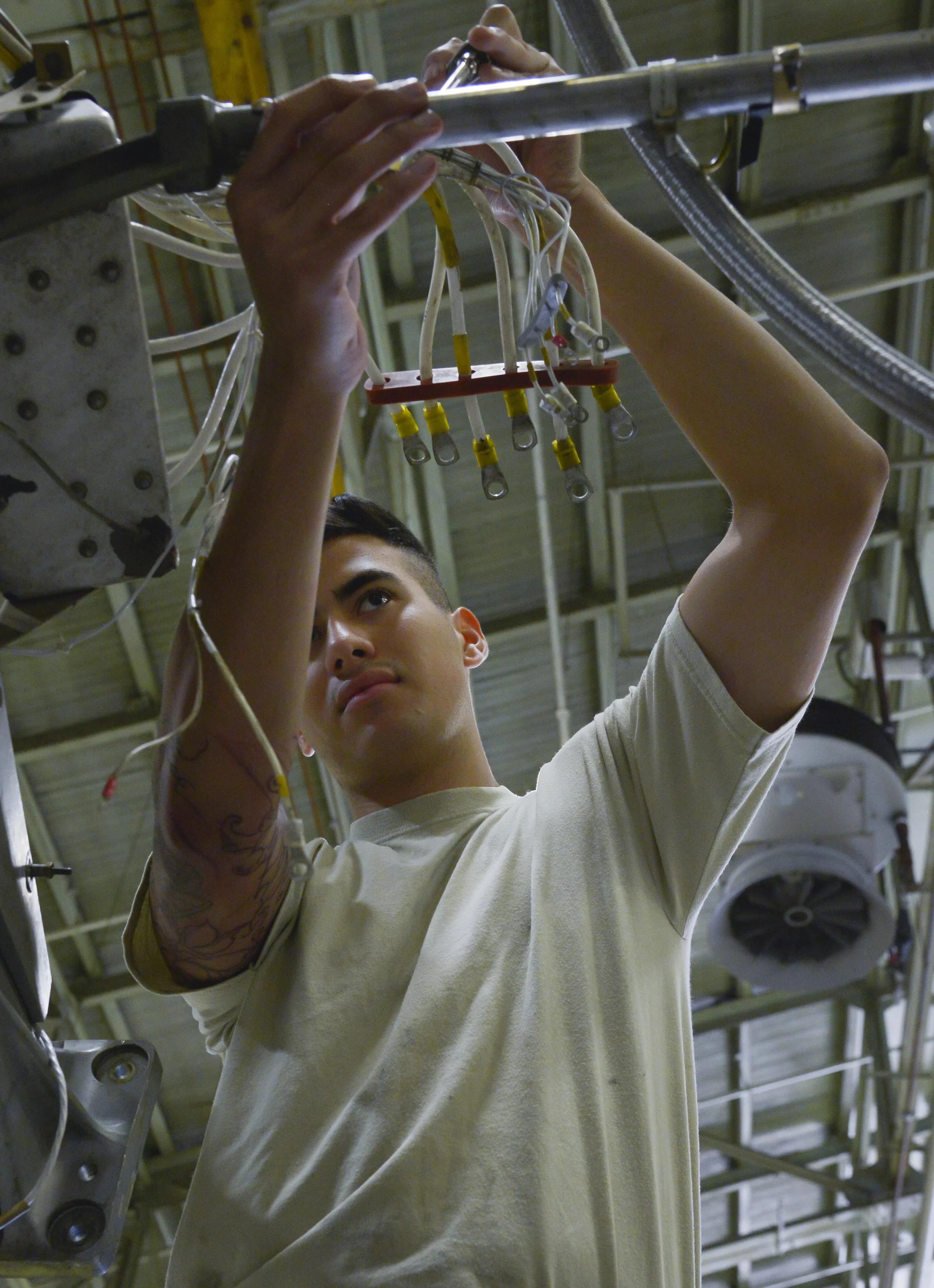 Airman 1st Class Gage Walker, 374th Maintenance Squadron propulsion flight aerospace propulsion apprentice, routes a generator harness on a quick engine change kit at Yokota Air Base, Japan, Sept. 23, 2015. The flight provides engines and propellers for the C-130 Hercules to make sure the aircraft can fly to perform airlift and humanitarian missions throughout the Indo-Asia Pacific Region. (U.S. Air Force photo by Senior Airman David Owsianka/Released)