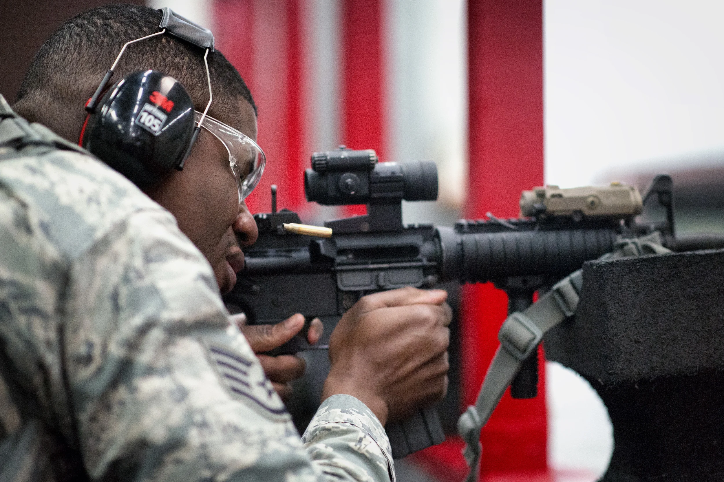 Staff Sgt. Louis Bradshaw, 374th Security Forces Squadron criminal investigator, fires an M-4 Carbine during a qualification test at Yokota Air Base, Japan, Oct. 8, 2015. In order to qualify for deployment in combat arms, each Airman must have at least a score of 44 out of 63 rounds to pass. (U.S. Air Force photo by Airman 1st Class Delano Scott/Released)