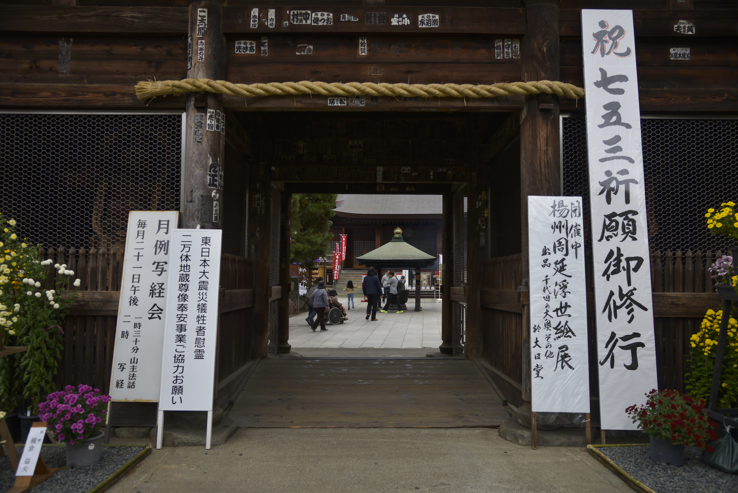 People walk towards a chuzo at the Takahata Fudo Temple grounds in Hino City, Japan, Nov. 1, 2015. Chozu’s are used to purify a person’s hands and mouth before they pray. (U.S. Air Force photo by Senior Airman David Owsianka/Released)